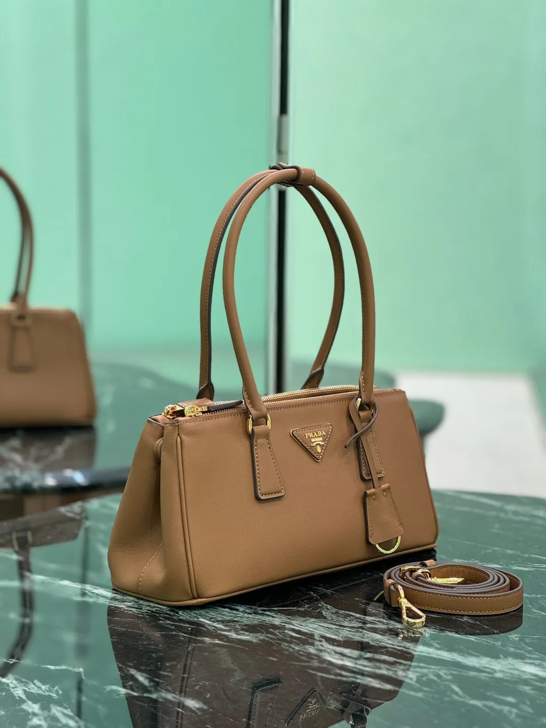 💰1760🌟Long handle killer bag Saffiano leather Double leather handles Removable adjustable leather shoulder strap Gold-plated hardware Removable leather key ring with metal engraved logo on triangular leather Side snap closure Two zippered outer pockets Three inner pockets, including one zippered pocket Soft sheepskin lining~ Dimensions: 30×14×11cm Model: 1BA457