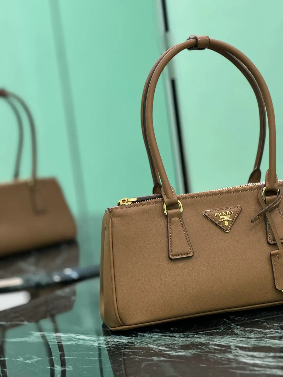 💰1760🌟Long handle killer bag Saffiano leather Double leather handles Removable adjustable leather shoulder strap Gold-plated hardware Removable leather key ring with metal engraved logo on triangular leather Side snap closure Two zippered outer pockets Three inner pockets, including one zippered pocket Soft sheepskin lining~ Dimensions: 30×14×11cm Model: 1BA457