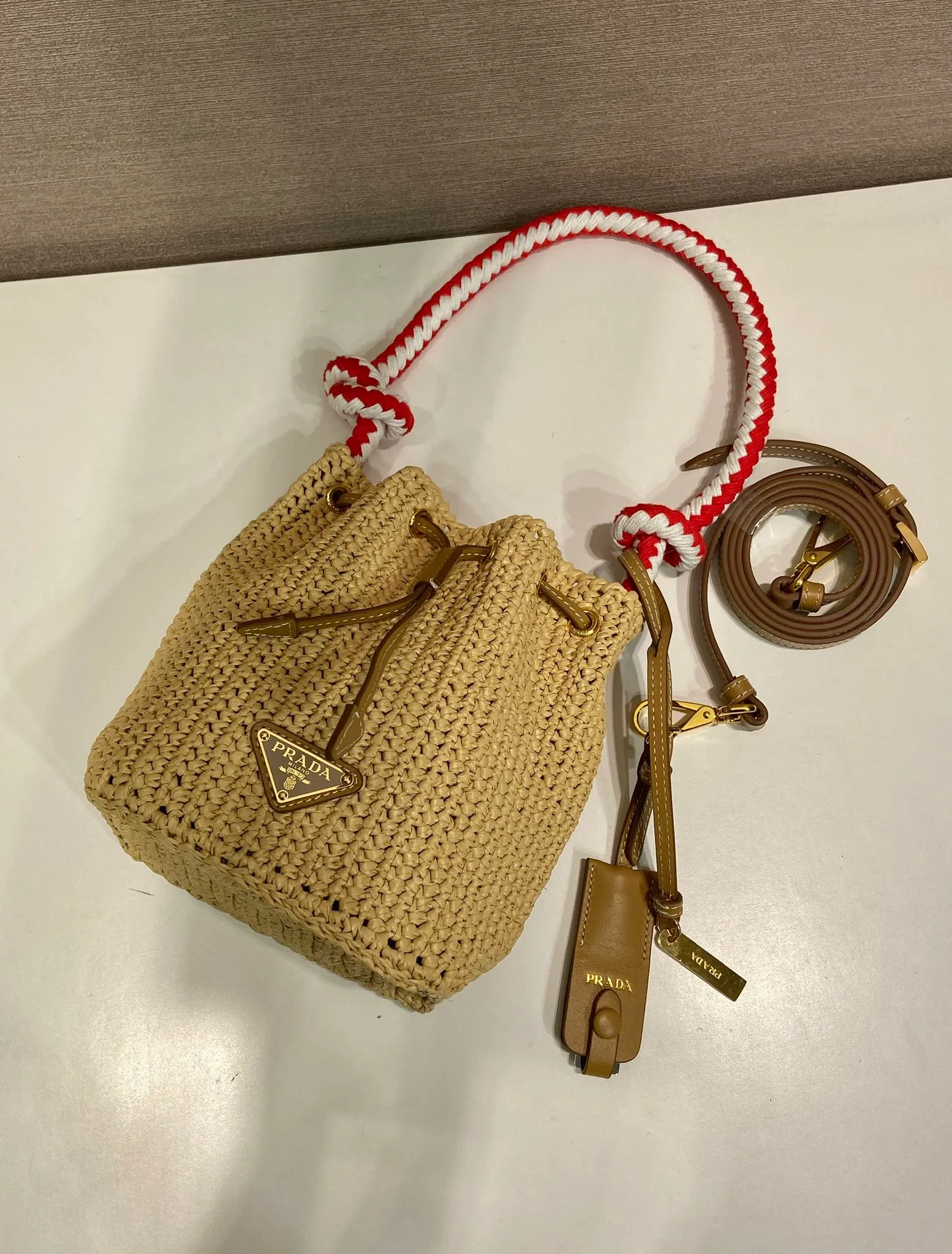 💰1360🎉New woven 🎉1BE068 bucket bag🎉🎉 This woven bucket bag is made of imported raffia material. Purely handwoven. Cotton rope carry handles. Detachable and adjustable leather shoulder strap. Detachable leather keychain, metal hardware accessories, drawstring closure, large capacity, it is a popular style that will never go out of style, hurry up and get it🎉🎉 Length 19.5x Height 15.5x Bottom 10cm🎉🎉🎉💰💰💰