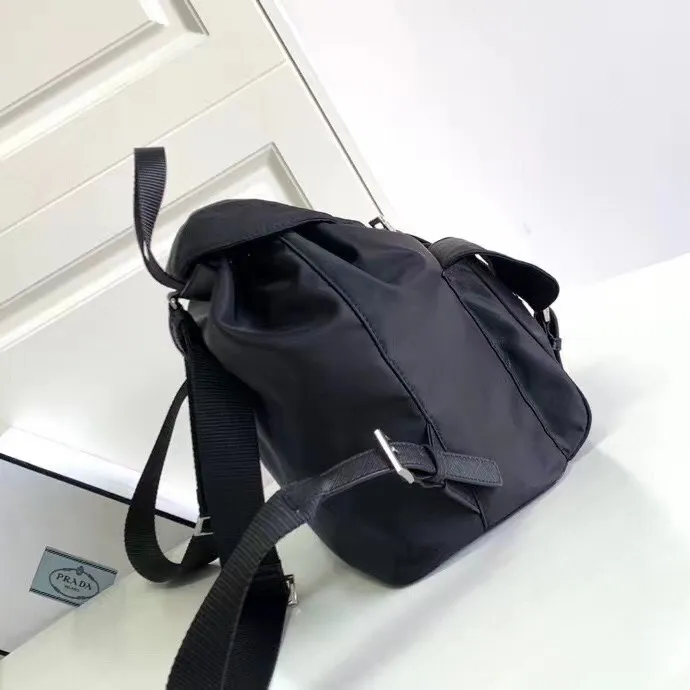 P640¥PR@DA 1BZ811 Nylon backpack is the most classic, best-selling and most versatile backpack of the P family. It is the first nylon bag designed by the chief founder himself. It is lightweight, rainproof, has a moderate capacity and is suitable for travel. It is matched with imported parachute fabric - waterproof and sunproof. Triangular enamel logo on the front, cross pattern cowhide trim. The overall style is fashionable and casual, yet stable and dignified. It has a large capacity to hold a kettle, iPad, mobile phone, books and documents. The drawstring inner bag + the two front zipper outer pockets meet the exquisite storage needs [Celebration]: 32*30*15cm black