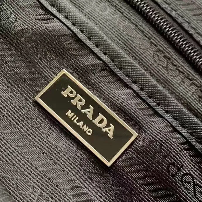 P640¥PR@DA 1BZ811 Nylon backpack is the most classic, best-selling and most versatile backpack of the P family. It is the first nylon bag designed by the chief founder himself. It is lightweight, rainproof, has a moderate capacity and is suitable for travel. It is matched with imported parachute fabric - waterproof and sunproof. Triangular enamel logo on the front, cross pattern cowhide trim. The overall style is fashionable and casual, yet stable and dignified. It has a large capacity to hold a kettle, iPad, mobile phone, books and documents. The drawstring inner bag + the two front zipper outer pockets meet the exquisite storage needs [Celebration]: 32*30*15cm black