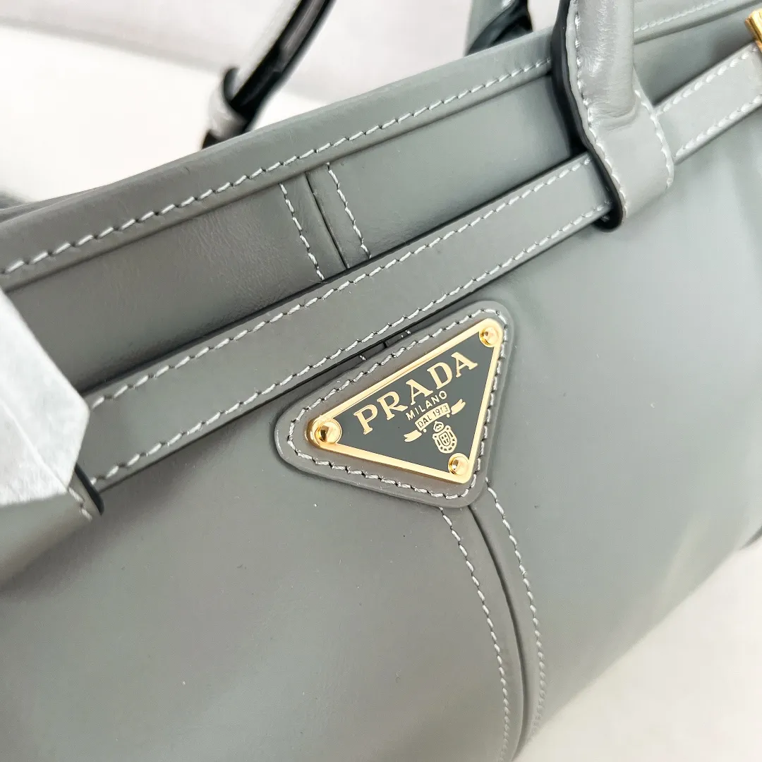 💰1840✨New model debut✨Oil-wax leather LuxSoft handbag small size 1BA426 long handle New popular LuxSoftBag Retro oil-wax leather with gold hardware Iconic triangle logo Comes with a long shoulder strap Can be carried on one shoulder or crossbody The fashionable feel is straight forward Size 32*15.5*12 blue gray