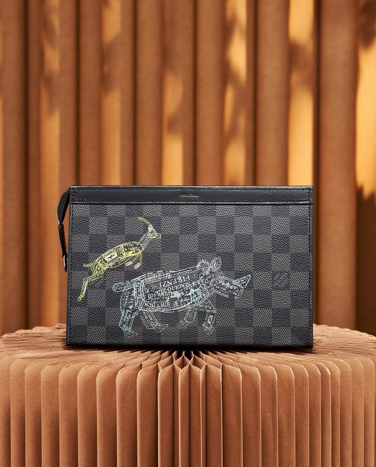 P¥640 [Top Original Order] N64608 This cross-body clutch and dual-use Gaston Wearable Wallet handbag is made of Damier Graphite canvas, with a customs seal-style pattern on the checkerboard surface to show the scene of charging elephants, tigers and ostriches. A removable card holder attached to the shoulder strap allows for touch-free payment. Dimensions: 22 x 14.5 x 4.5 cm