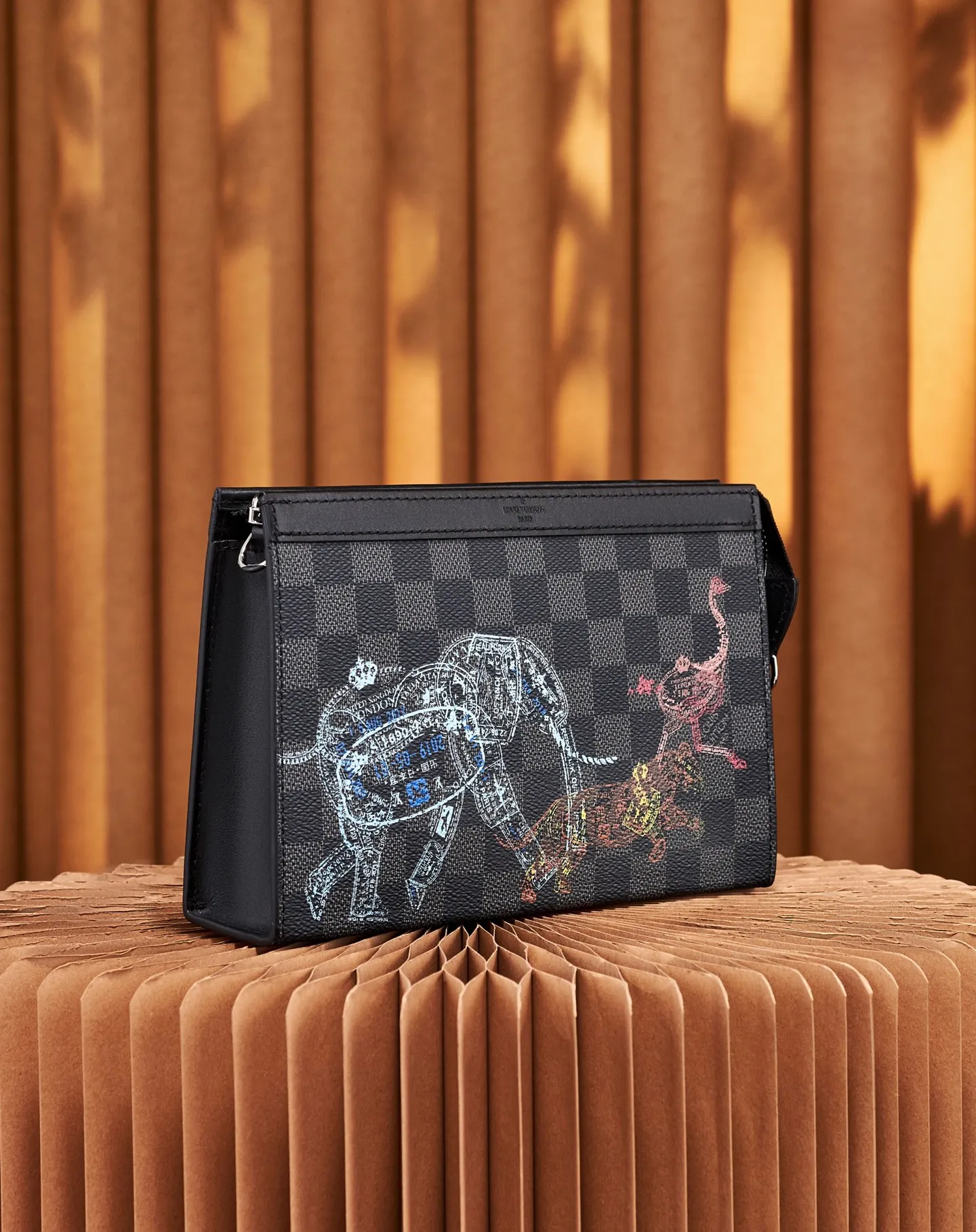 P¥640 [Top Original Order] N64608 This cross-body clutch and dual-use Gaston Wearable Wallet handbag is made of Damier Graphite canvas, with a customs seal-style pattern on the checkerboard surface to show the scene of charging elephants, tigers and ostriches. A removable card holder attached to the shoulder strap allows for touch-free payment. Dimensions: 22 x 14.5 x 4.5 cm