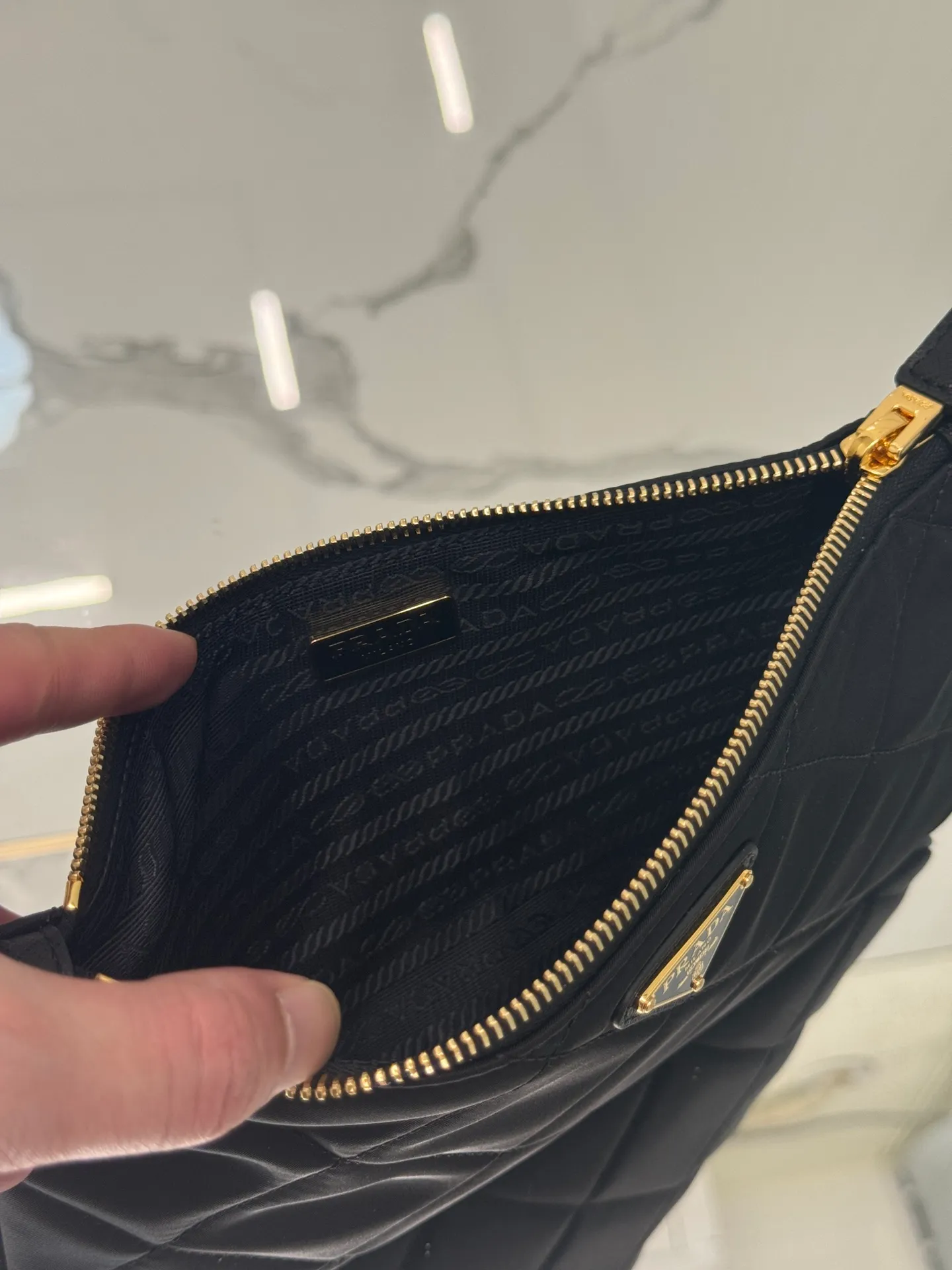 💰700🌟Chain Underarm Bag This clutch bag is made of regenerated nylon (Re-Nylon), which reflects the sustainable evolution of Prada's iconic fabric and adopts a simple and elegant design. Embodying the duality at the core of the brand, it cleverly blends modern and practical regenerated nylon with charming and refined details. It features chain handles, tonal stitching and the signature enameled triangle metal logo. Size: 24.5×14cm Style number: 1NI054