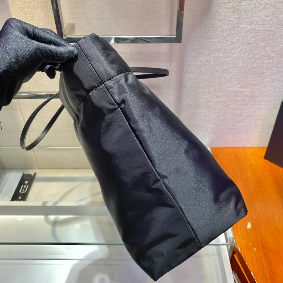💰920🎉New Tote Bag🎉1BG107🎉This medium tote bag is made of innovative recycled nylon fabric with a simple and stylish design. The body of the bag is equipped with exquisite Saffiano leather handles and is decorated with the iconic enameled triangle metal logo to convey the brand message. Large space capacity 👍 Very practical 👍 Stylish and simple, it is also a shopping bag that will never go out of style. If you like babies, hurry up and get it 😘😘 Length 40x Height 34x Bottom 16cm