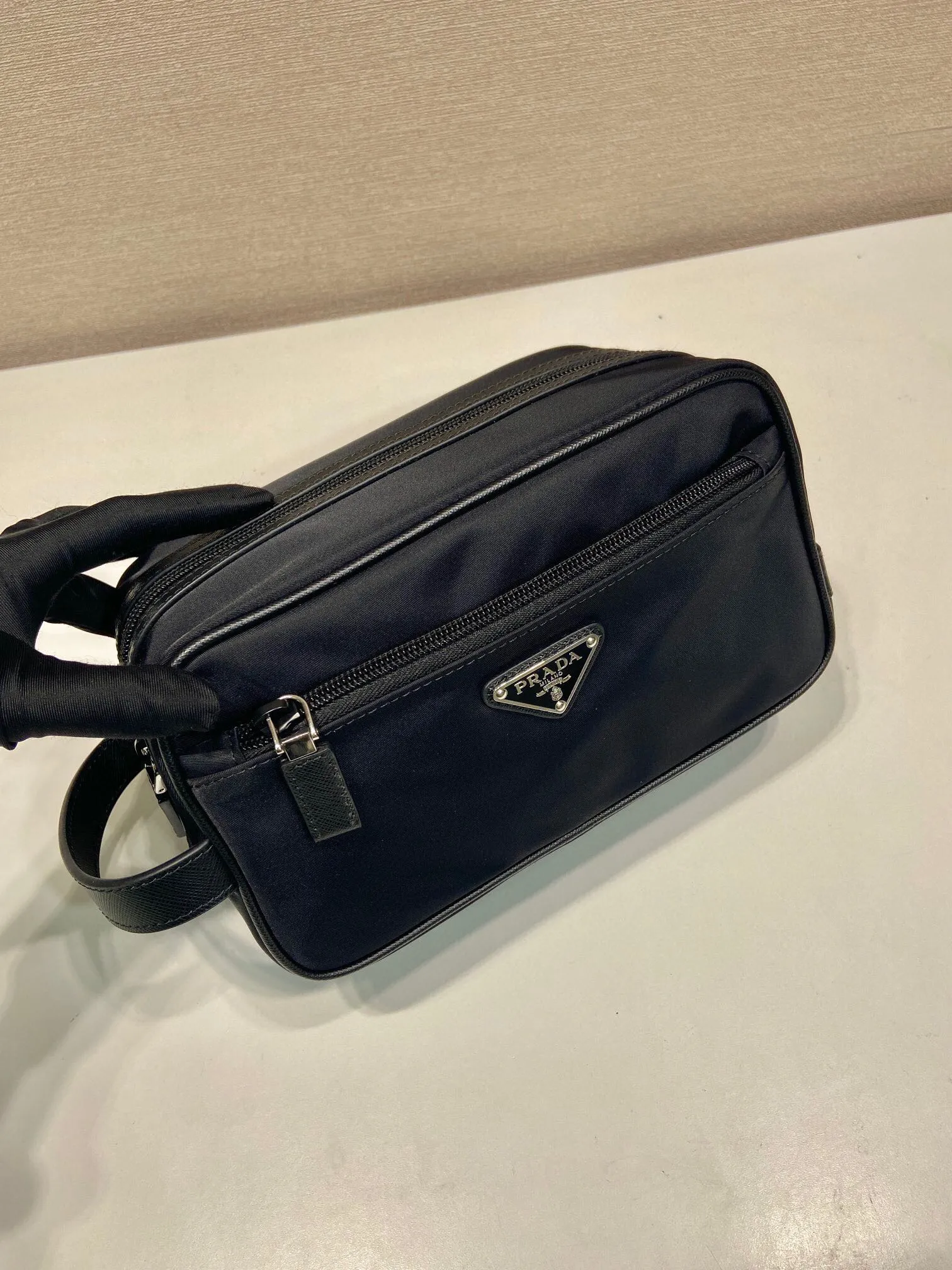 P¥420 [Dongguan Factory Special] 🎉 New toiletry bag 🎉 2NA819 storage bag 🎉🎉 This travel storage bag is made of Re-Nylon regenerated nylon material, with a simple and elegant design. The storage bag is equipped with a top zipper, decorated with an enameled triangle logo and a Saffiano hand strap, and two external zippered pockets The internal zippered pocket is very practical. It can be used as a handbag or a travel storage/toilet bag. Baby, hurry up and get it🎉🎉 Length 22x Height 12.5x Bottom length 11🎉🎉🎉