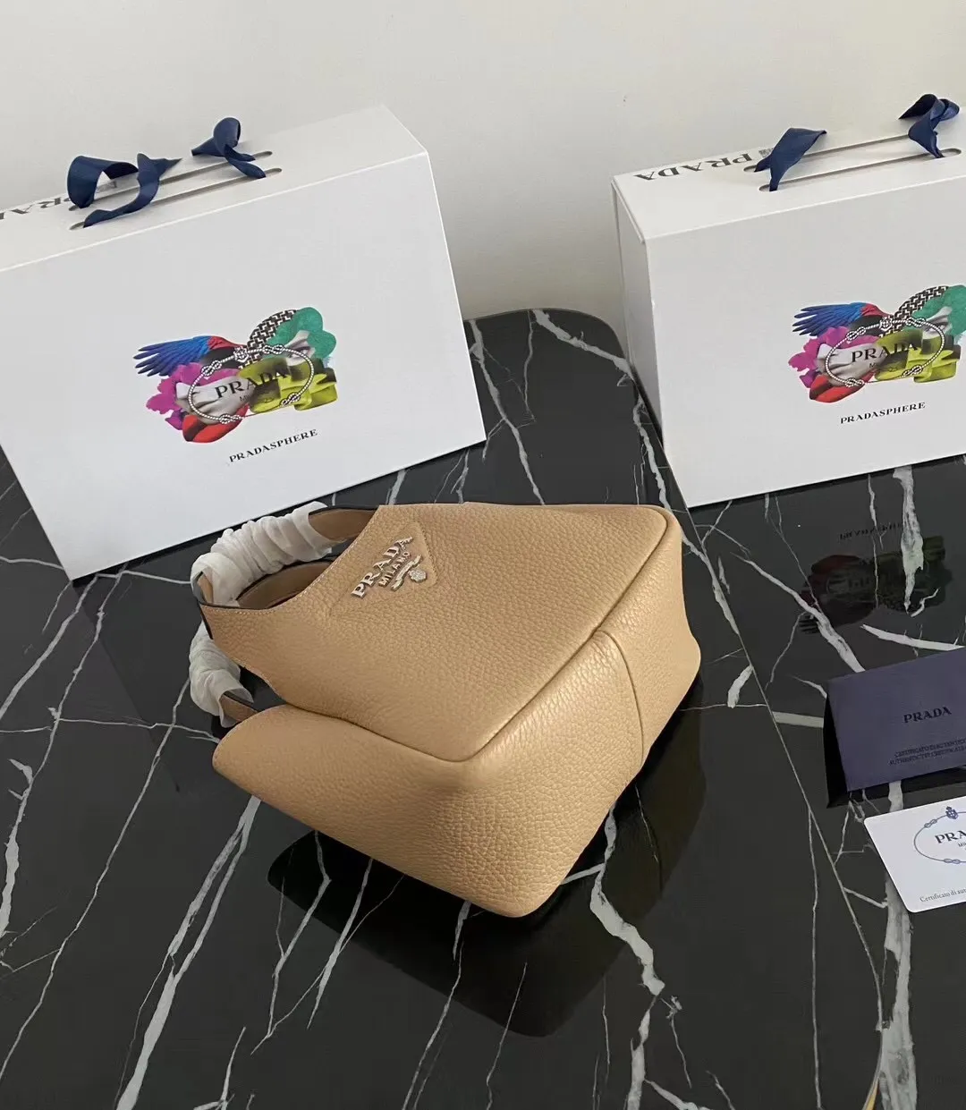 P1100¥ [Top original order] The latest 2022 vegetable basket tote bag mini model 1BA349 has arrived🎉🎉Soft and delicate pebbled calfskin tote bag, full leather inside and outside, equipped with double handles, decorated with silver metal logo, the overall body of the bag is very soft Lightweight, elegant and outstanding. The two side pockets not only meet the needs of exquisite storage but also add an elegant charm. It can be carried as a handbag or an armpit bag. It is a must-have handbag for fairies that perfectly combines classic heritage with the trend of the times. Size: 18︸15.5︸10CM!