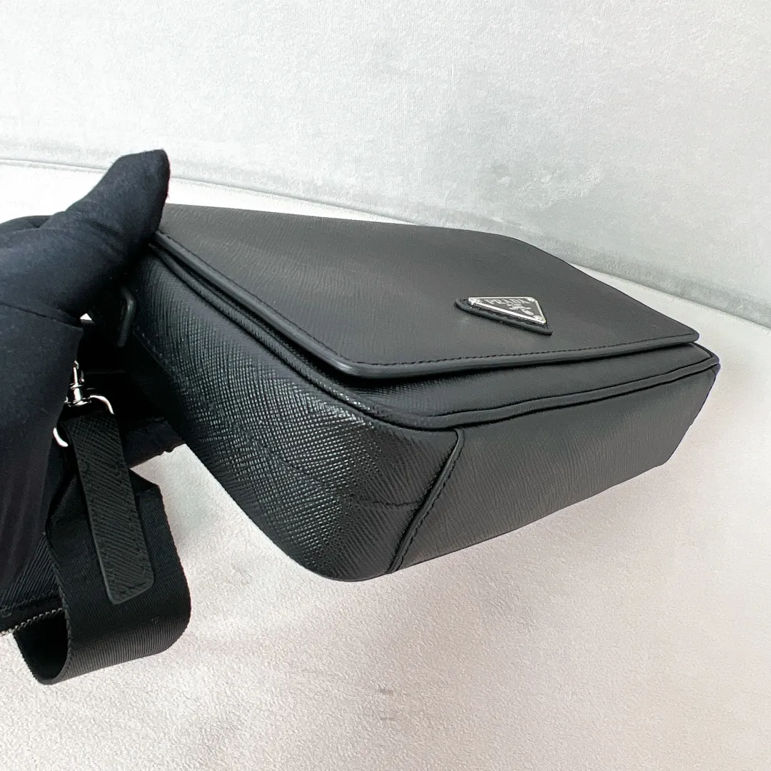 💰1700✨New product launch✨2023 latest men's full leather messenger bag 2VD059 This cross-grain cowhide messenger bag interprets an exquisite structural silhouette. The classic triangle logo on the front comes with an external coin purse. Magnetic buckle flap closure. Adjustable nylon with leather shoulder strap. It highlights the unique temperament and is versatile and casual. Multiple pockets meet the needs of exquisite storage. Size: 22*14.5*5cm black