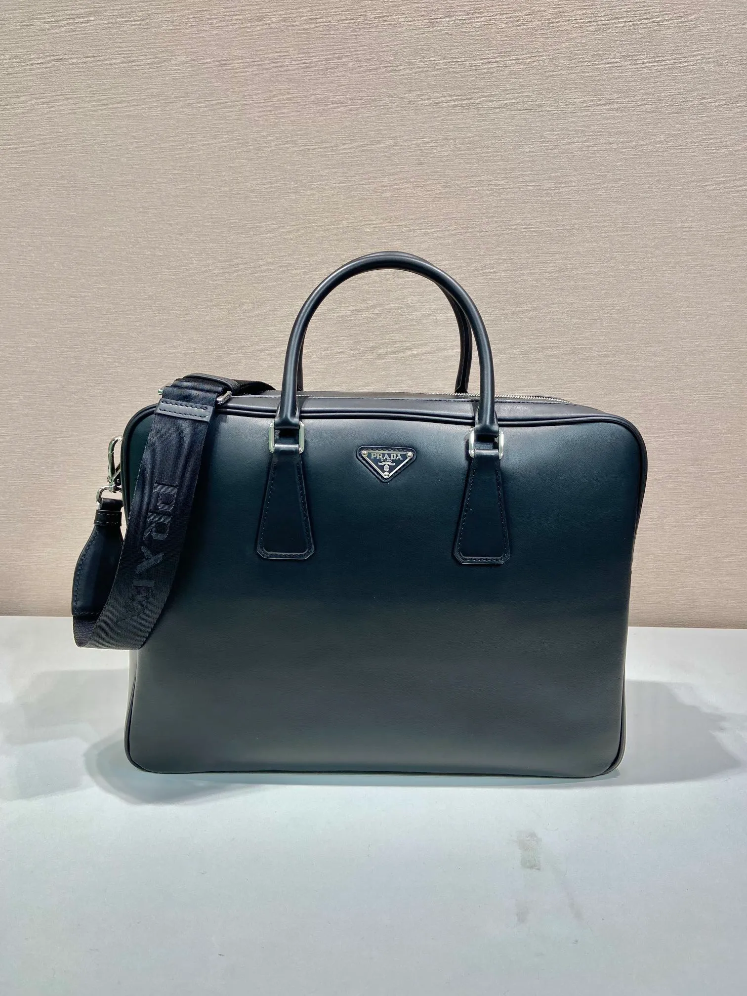 💰2100🎉Double Layer Briefcase🎉2VE025 New Arrival🎉🎉 This elegant and versatile leather briefcase is designed with two compartments and features a removable and adjustable Re-Nylon webbing shoulder strap. Made of premium calfskin, the enameled metal triangle logo is vividly embellished on the front, adding a signature element. Simple/practical/grand, handsome guys. Hurry up and get it🎉🎉Length 39x Height 29x Bottom 12cm🎉🎉🎉👏👏👏