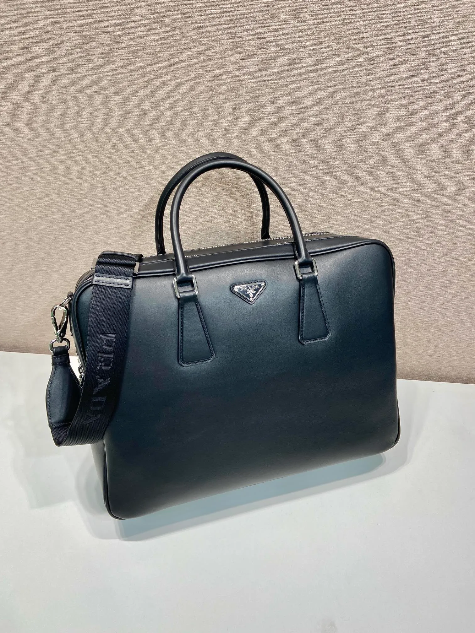 💰2100🎉Double Layer Briefcase🎉2VE025 New Arrival🎉🎉 This elegant and versatile leather briefcase is designed with two compartments and features a removable and adjustable Re-Nylon webbing shoulder strap. Made of premium calfskin, the enameled metal triangle logo is vividly embellished on the front, adding a signature element. Simple/practical/grand, handsome guys. Hurry up and get it🎉🎉Length 39x Height 29x Bottom 12cm🎉🎉🎉👏👏👏