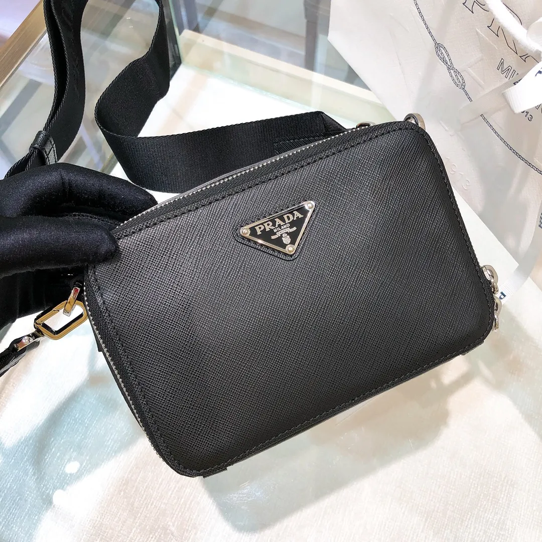 💰1120✨New first launch✨ 2VH070 men's new camera📷bag The trendy representative among p-family camera bags📷 Imported Saffiano cross-grain cowhide The main compartment is zippered and equipped with internal pockets Adjustable nylon shoulder straps decorated with jacquard logo Unique design Fashion leader Outstanding temperament The overall body of the bag is very textured Cross-grain cowhide is crisp and stylish size：18*12*5.5cm