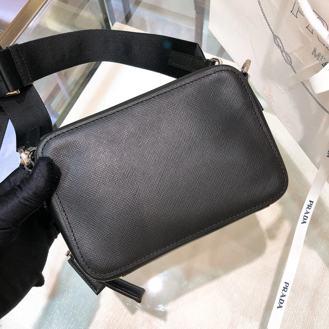 💰1120✨New first launch✨ 2VH070 men's new camera📷bag The trendy representative among p-family camera bags📷 Imported Saffiano cross-grain cowhide The main compartment is zippered and equipped with internal pockets Adjustable nylon shoulder straps decorated with jacquard logo Unique design Fashion leader Outstanding temperament The overall body of the bag is very textured Cross-grain cowhide is crisp and stylish size：18*12*5.5cm