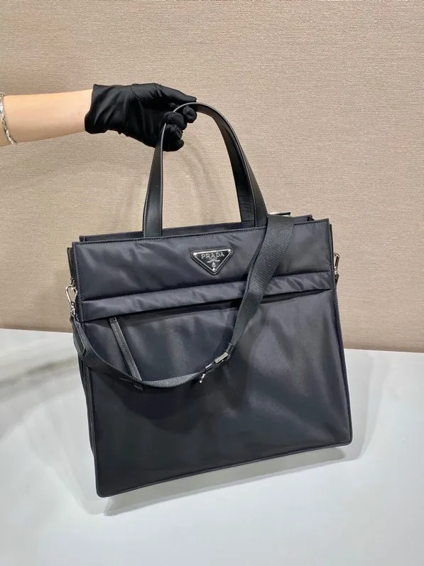 💰1460🎉Upgraded Tote Bag🎉2VG076 This tote bag has a compact square design and is decorated with leather details. The iconic enamel triangle logo on the front highlights the brand's style. Equipped with a detachable long shoulder strap, the bag body is made of Re-Nylon regenerated nylon, which can be called the evolution of P's signature fabric selection. Lightweight and stylish, suitable for both men and women, get it now🎉🎉 Length 38x Height 36x Bottom 14cm