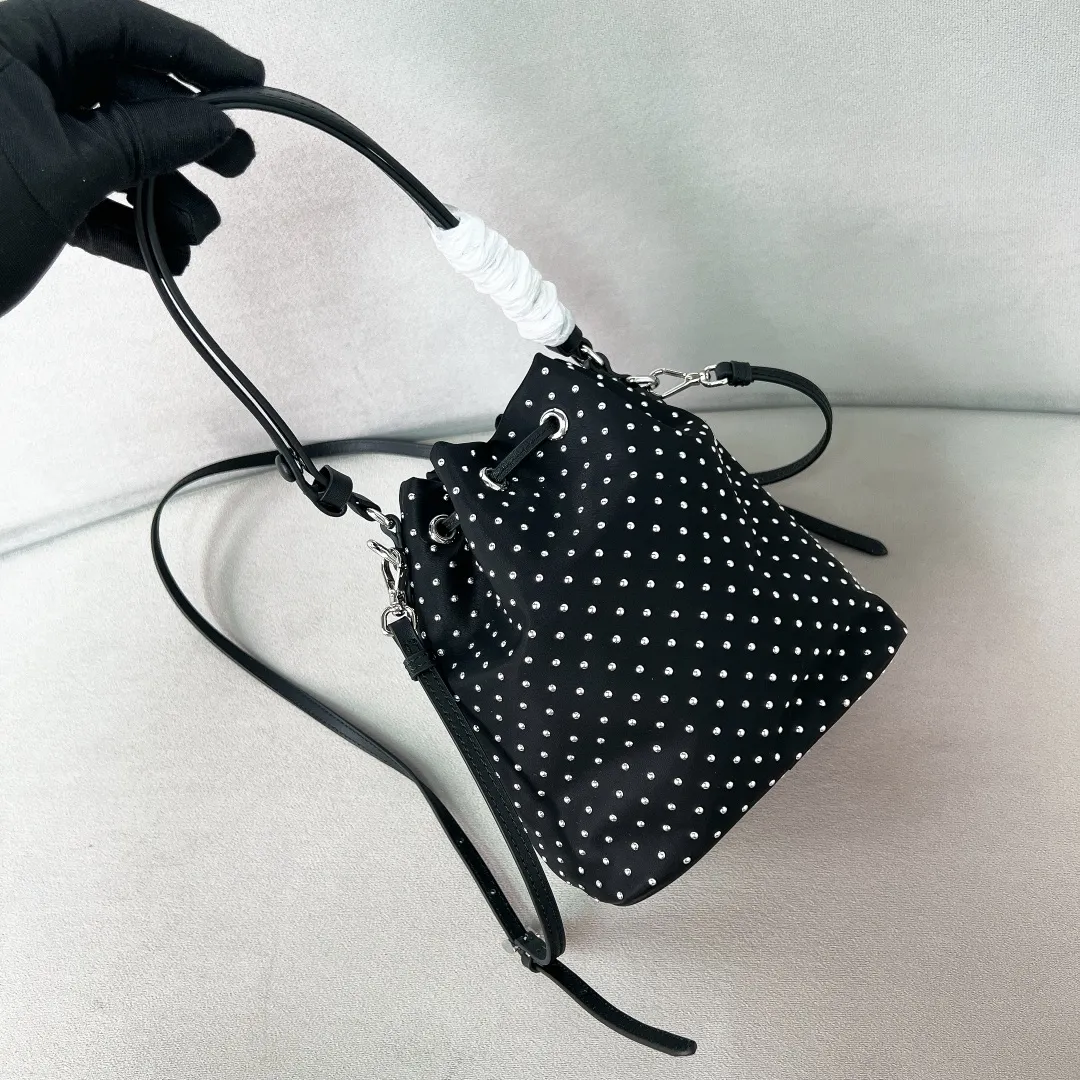 💰1140✨New product debut✨2025 new rivet decoration series bucket bag 1BE067 Imported recycled nylon fabric with rivet decoration Classic triangle logo Drawstring fastening design You can adjust the space at will Lightweight can be loaded and easy to match The randomness of different carrying methods and the ease of putting it anywhere Transform into a stylish girl in seconds🤩 Size：19.5/15.5/10