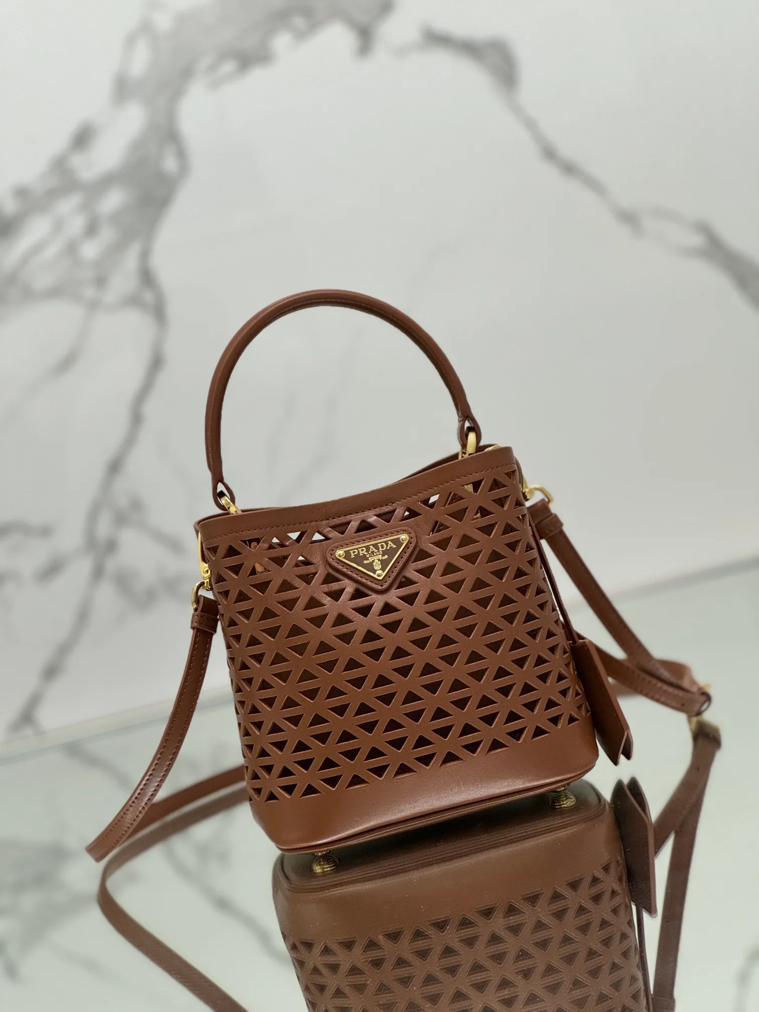 💰1640🌟Hollowout🐮Leather bucket bag The popular "elf" Saffiano perforated calfskin gives this P bucket bag a unique charm. The shape is not too soft and lacks spirit, nor is it too dull and lacks texture. The cute mini size adds a sense of fashion. It can be carried in hand, shoulder or crossbody. It is a handbag that perfectly integrates classic heritage and the trend of the times. Size: 18×17×10.5 cm Style number: 1BA217