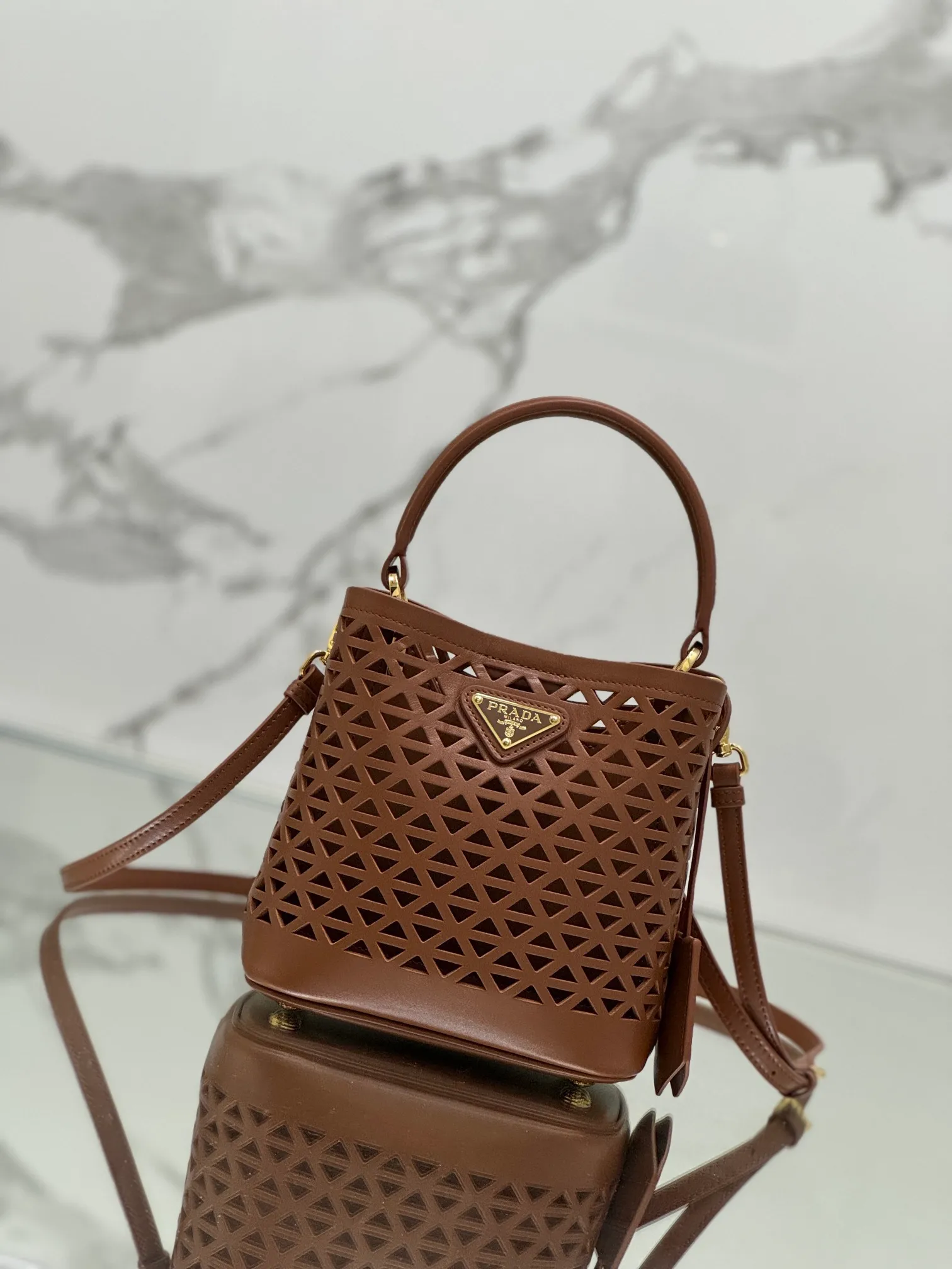 💰1640🌟Hollowout🐮Leather bucket bag The popular "elf" Saffiano perforated calfskin gives this P bucket bag a unique charm. The shape is not too soft and lacks spirit, nor is it too dull and lacks texture. The cute mini size adds a sense of fashion. It can be carried in hand, shoulder or crossbody. It is a handbag that perfectly integrates classic heritage and the trend of the times. Size: 18×17×10.5 cm Style number: 1BA217