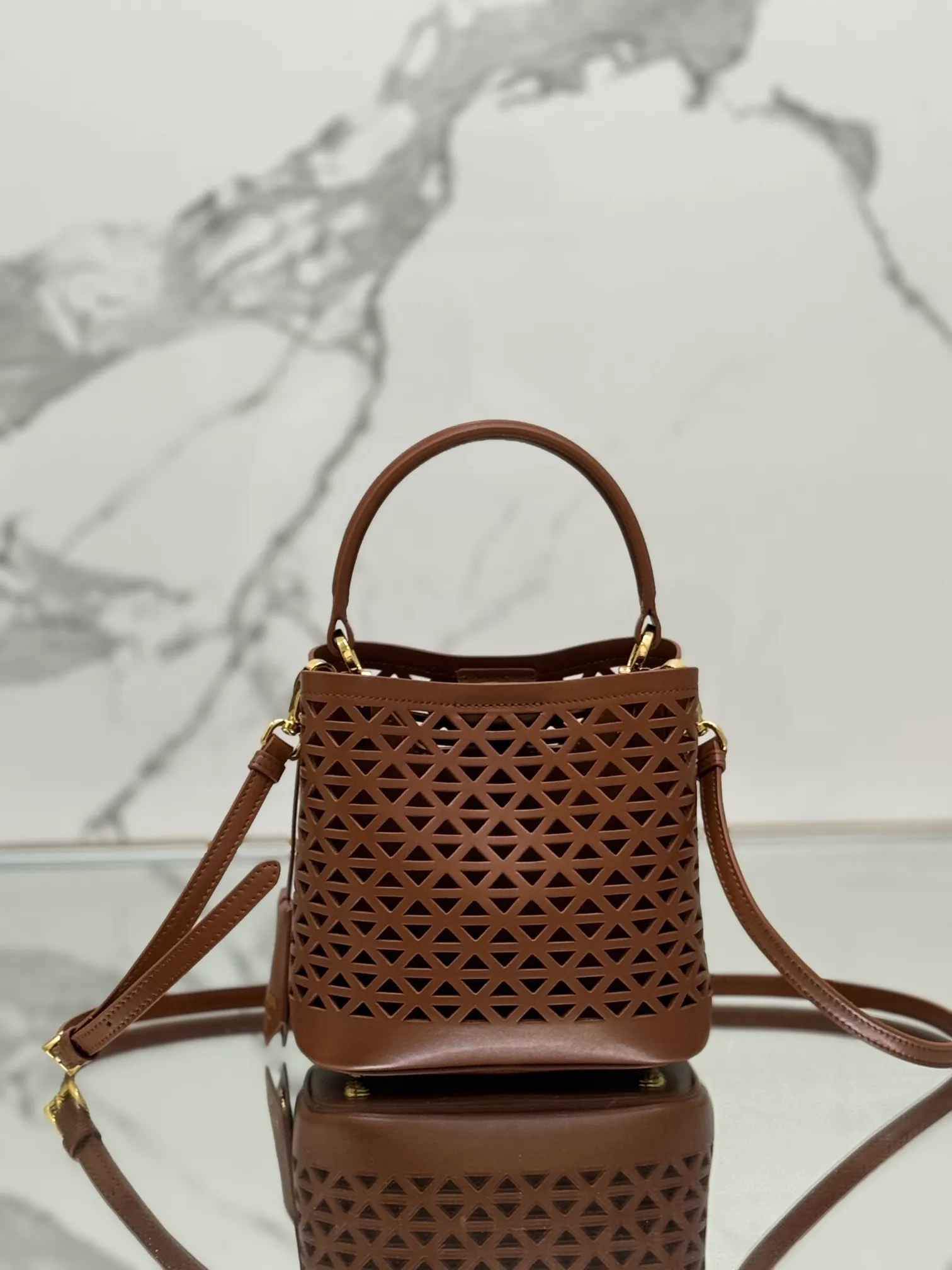 💰1640🌟Hollowout🐮Leather bucket bag The popular "elf" Saffiano perforated calfskin gives this P bucket bag a unique charm. The shape is not too soft and lacks spirit, nor is it too dull and lacks texture. The cute mini size adds a sense of fashion. It can be carried in hand, shoulder or crossbody. It is a handbag that perfectly integrates classic heritage and the trend of the times. Size: 18×17×10.5 cm Style number: 1BA217