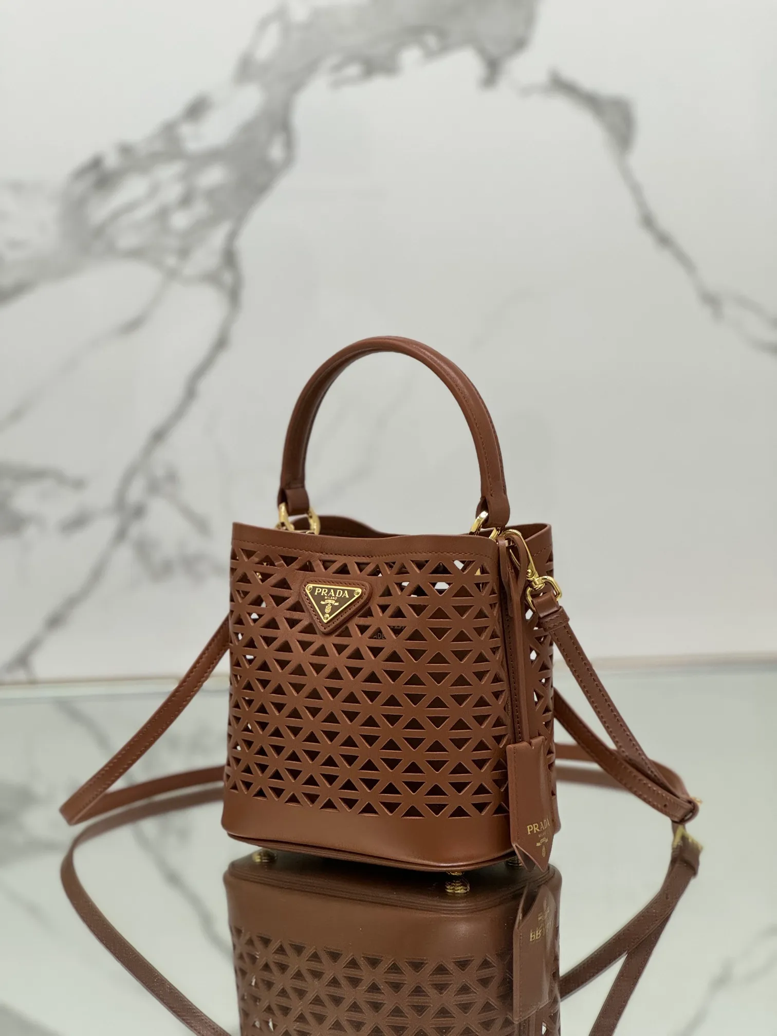 💰1640🌟Hollowout🐮Leather bucket bag The popular "elf" Saffiano perforated calfskin gives this P bucket bag a unique charm. The shape is not too soft and lacks spirit, nor is it too dull and lacks texture. The cute mini size adds a sense of fashion. It can be carried in hand, shoulder or crossbody. It is a handbag that perfectly integrates classic heritage and the trend of the times. Size: 18×17×10.5 cm Style number: 1BA217