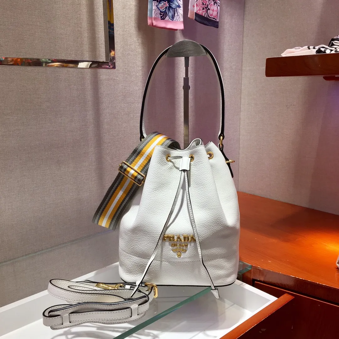 💰1660, P family has another popular bucket bag👏🏻👏🏻1BE018, the latest/most popular bucket bag🤙🤙Made of imported calfskin deerskin grain material, leather handle/2 replacement shoulder straps👏🏻👏🏻Detachable and adjustable colorful fabric shoulder straps, equipped with leather shoulder pads, metal lettering logo Decorated with a leather drawstring on the top, logo lining, there is a leather pocket inside, a large capacity and beautiful style🙋🏻🙋🏻, length 21x height 25x bottom 15cm.🤙🤙🤙💰💰💰