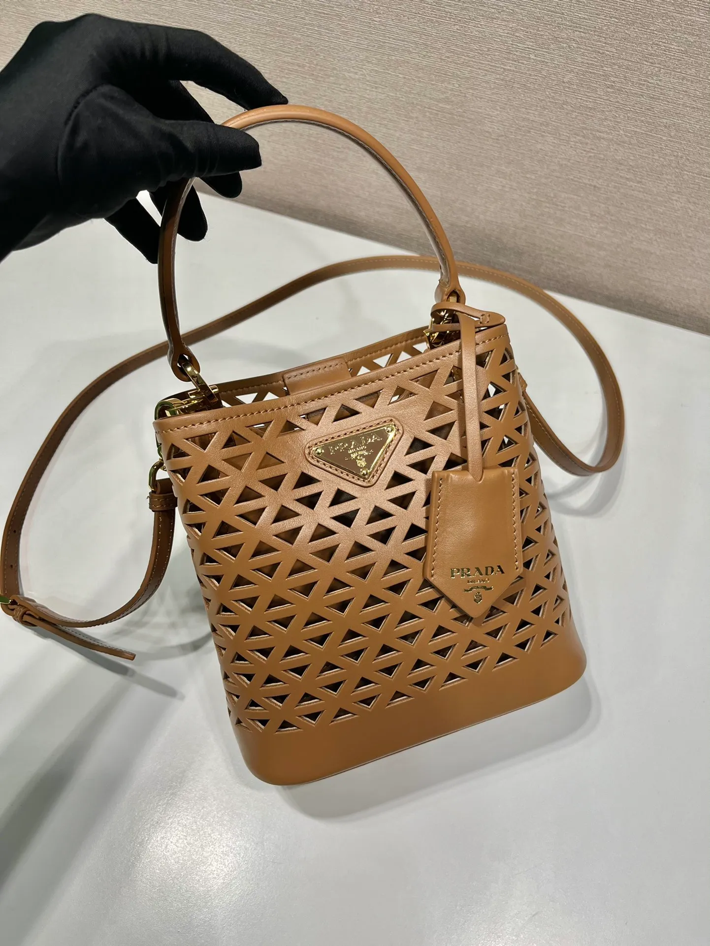 💰1640🎉Skeleton Bucket Bag🎉1BA217 Skeleton🎉🎉 This hollow bucket bag transforms the classic triangle into a modernist geometric pattern, injecting vitality into the elegant design. It has a compact shape and a detachable shoulder strap, suitable for hand or shoulder carry. It is made of laser-cut patterned leather, adding a touch of summer lightness and unique style. Sophisticated and elegant, it features a leather plaque and enameled metal triangle logo. The upper body effect is very fashionable and elegant, worth owning🎉🎉 Length 17x Height 18x ​​Bottom 10.5cm