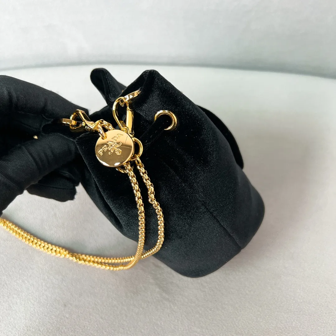 💰900✨New product launch✨2025 early spring new velvet fabric mini lucky bag 1NR016. Carefully crafted from exquisite and elegant velvet fabric. Equipped with metal chain➕triangle logo➕small gold circle. Super cute little lucky bag shape with lots of blessings. Simple, exquisite and shiny. It can be worn on one shoulder or crossbody. It is simply great👏...the new favorite of fashion trendsetters The perfect details are comparable to brick cabinets. Super 5🌟review Size: 9.5*9*6cm black