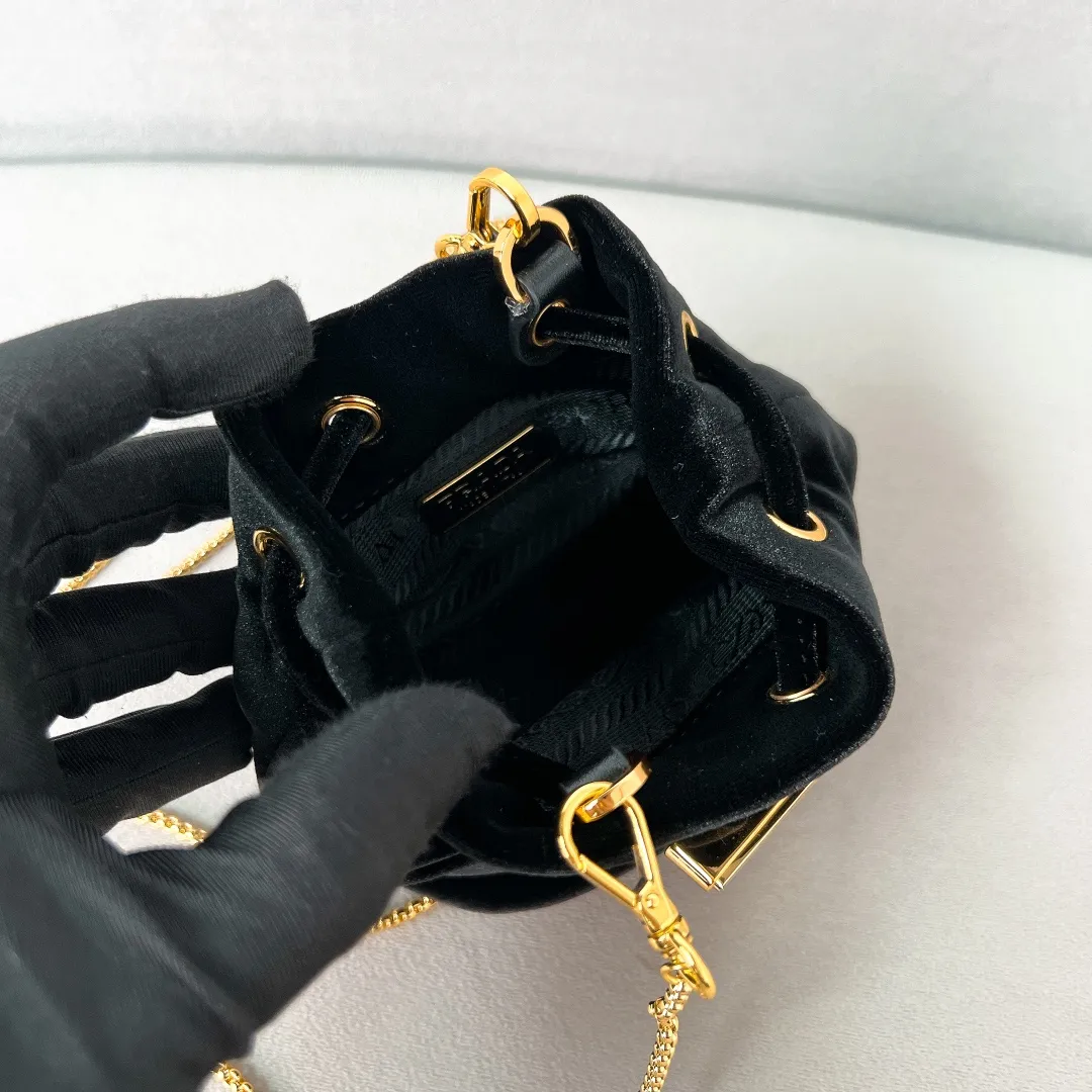 💰900✨New product launch✨2025 early spring new velvet fabric mini lucky bag 1NR016. Carefully crafted from exquisite and elegant velvet fabric. Equipped with metal chain➕triangle logo➕small gold circle. Super cute little lucky bag shape with lots of blessings. Simple, exquisite and shiny. It can be worn on one shoulder or crossbody. It is simply great👏...the new favorite of fashion trendsetters The perfect details are comparable to brick cabinets. Super 5🌟review Size: 9.5*9*6cm black