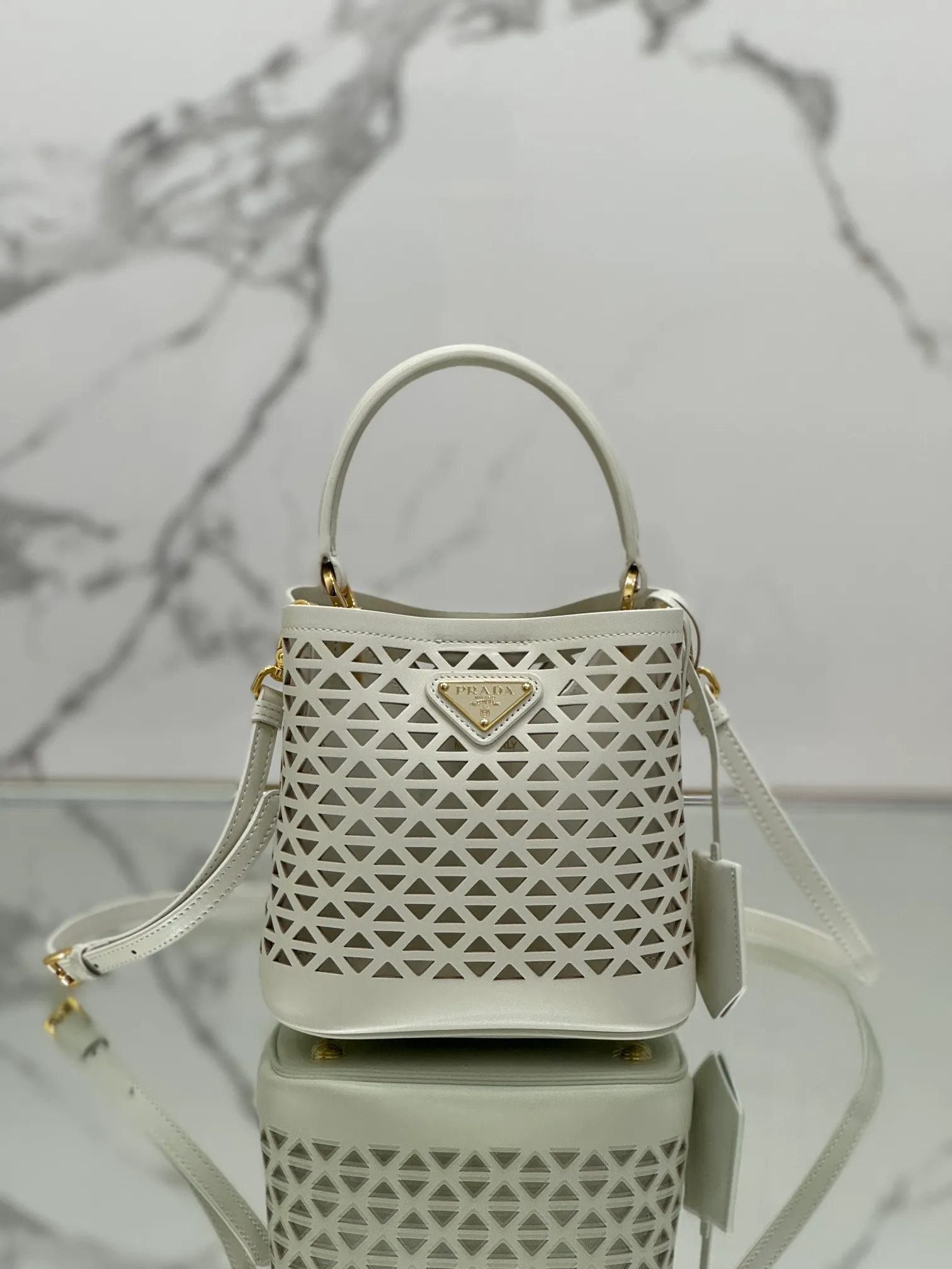 💰1640🌟Hollowout🐮Leather bucket bag The popular "elf" Saffiano perforated calfskin gives this P bucket bag a unique charm. The shape is not too soft and lacks spirit, nor is it too dull and lacks texture. The cute mini size adds a sense of fashion. It can be carried in hand, shoulder or crossbody. It is a handbag that perfectly integrates classic heritage and the trend of the times. Size: 18×17×10.5 cm Style number: 1BA217