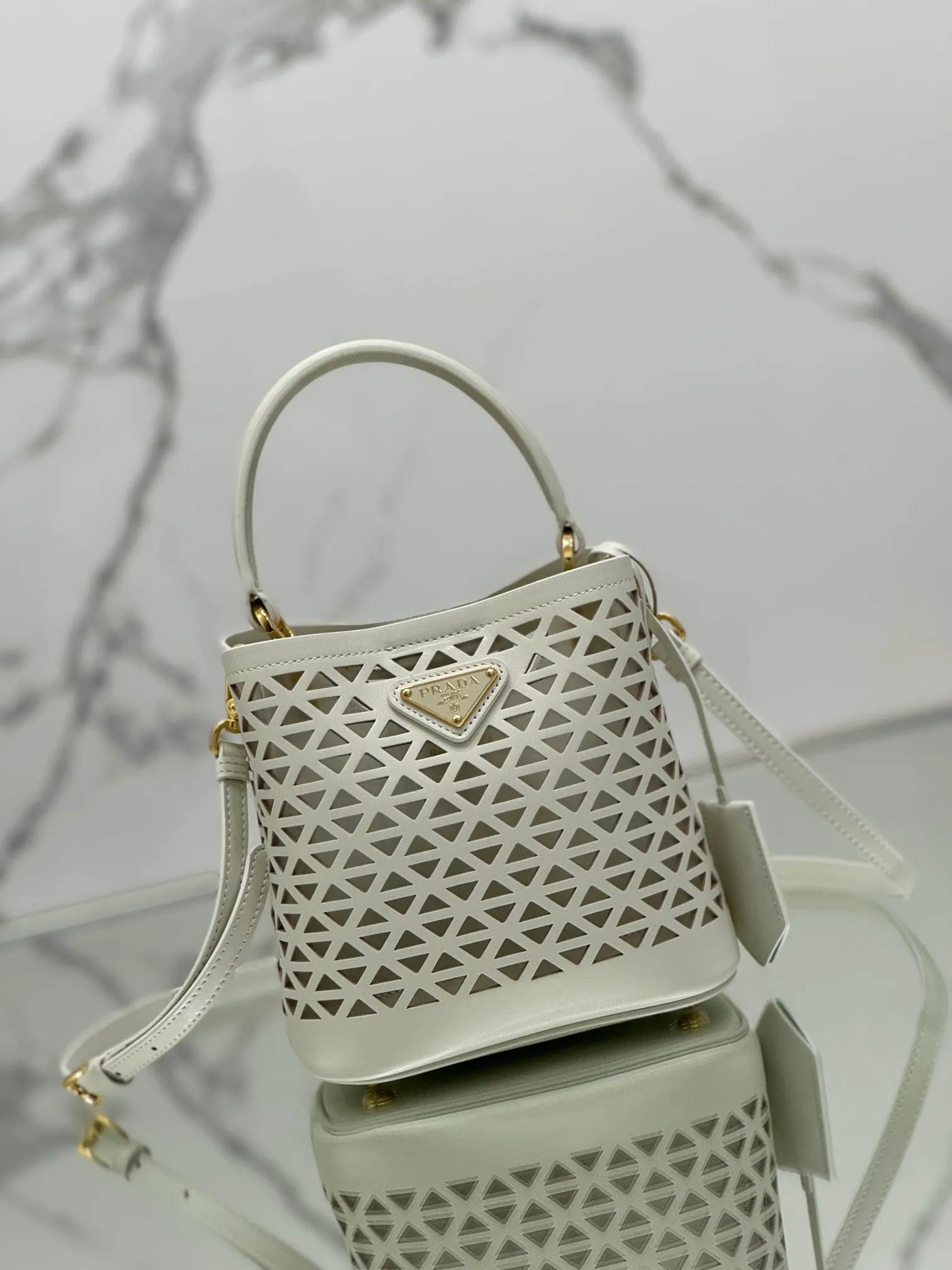 💰1640🌟Hollowout🐮Leather bucket bag The popular "elf" Saffiano perforated calfskin gives this P bucket bag a unique charm. The shape is not too soft and lacks spirit, nor is it too dull and lacks texture. The cute mini size adds a sense of fashion. It can be carried in hand, shoulder or crossbody. It is a handbag that perfectly integrates classic heritage and the trend of the times. Size: 18×17×10.5 cm Style number: 1BA217