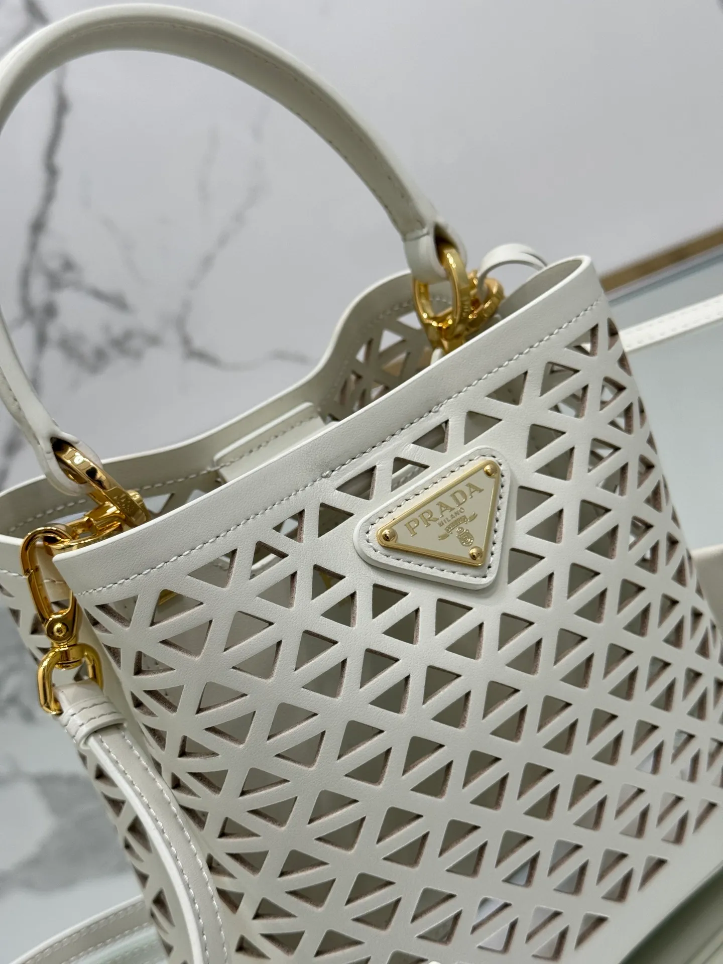💰1640🌟Hollowout🐮Leather bucket bag The popular "elf" Saffiano perforated calfskin gives this P bucket bag a unique charm. The shape is not too soft and lacks spirit, nor is it too dull and lacks texture. The cute mini size adds a sense of fashion. It can be carried in hand, shoulder or crossbody. It is a handbag that perfectly integrates classic heritage and the trend of the times. Size: 18×17×10.5 cm Style number: 1BA217