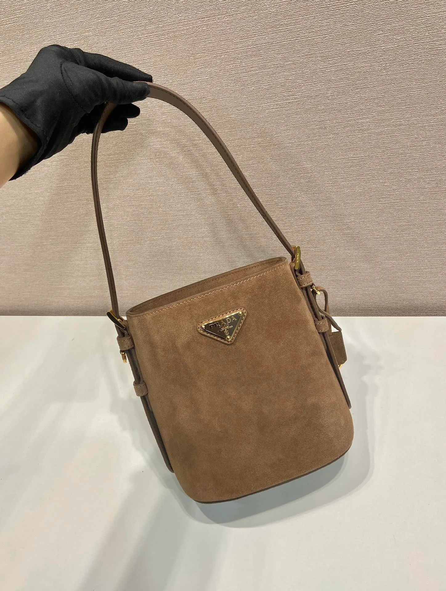 💰1360🎉New Bucket Bag🎉1BE078A Suede Small Size🎉🎉 This flexible and easy-to-wear bucket bag has a minimalist design and is made of soft suede leather. The shoulder straps are adjustable and equipped with imported sheepskin inside. It has a large space and the upper body effect is fashionable. It is a must-have in winter and is worth owning👏👏👏 Length 17 height 18.5 bottom 10.5cm🎉🎉🎉👏👏👏