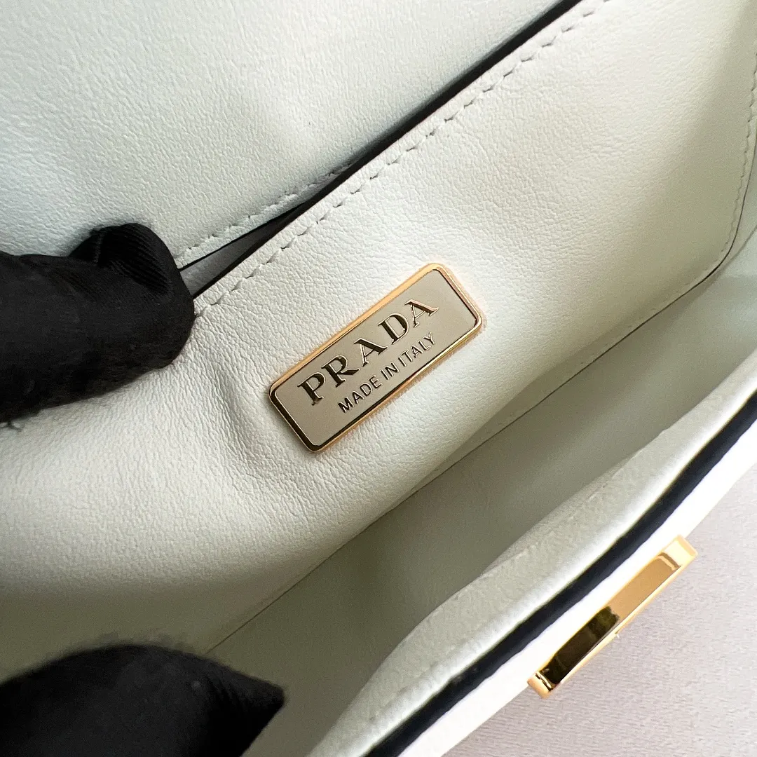 💰1360✨New product launch✨2024 spring and summer new series Saffiano shoulder bag 1BD356 is made of exquisite cross-grain cowhide and is equipped with the iconic triangle logo. It is equipped with a chain shoulder strap and a cross-body full leather shoulder strap. The shoulder strap is detachable and adjustable and can be carried under the armpit or on one shoulder. The overall style of the bag is simple and elegant. It combines fashion and retro style. The inner compartment capacity is also great. A new fashion trend-setter that combines retro fashion and practicality😘 Size 20.5*10.5*4 White