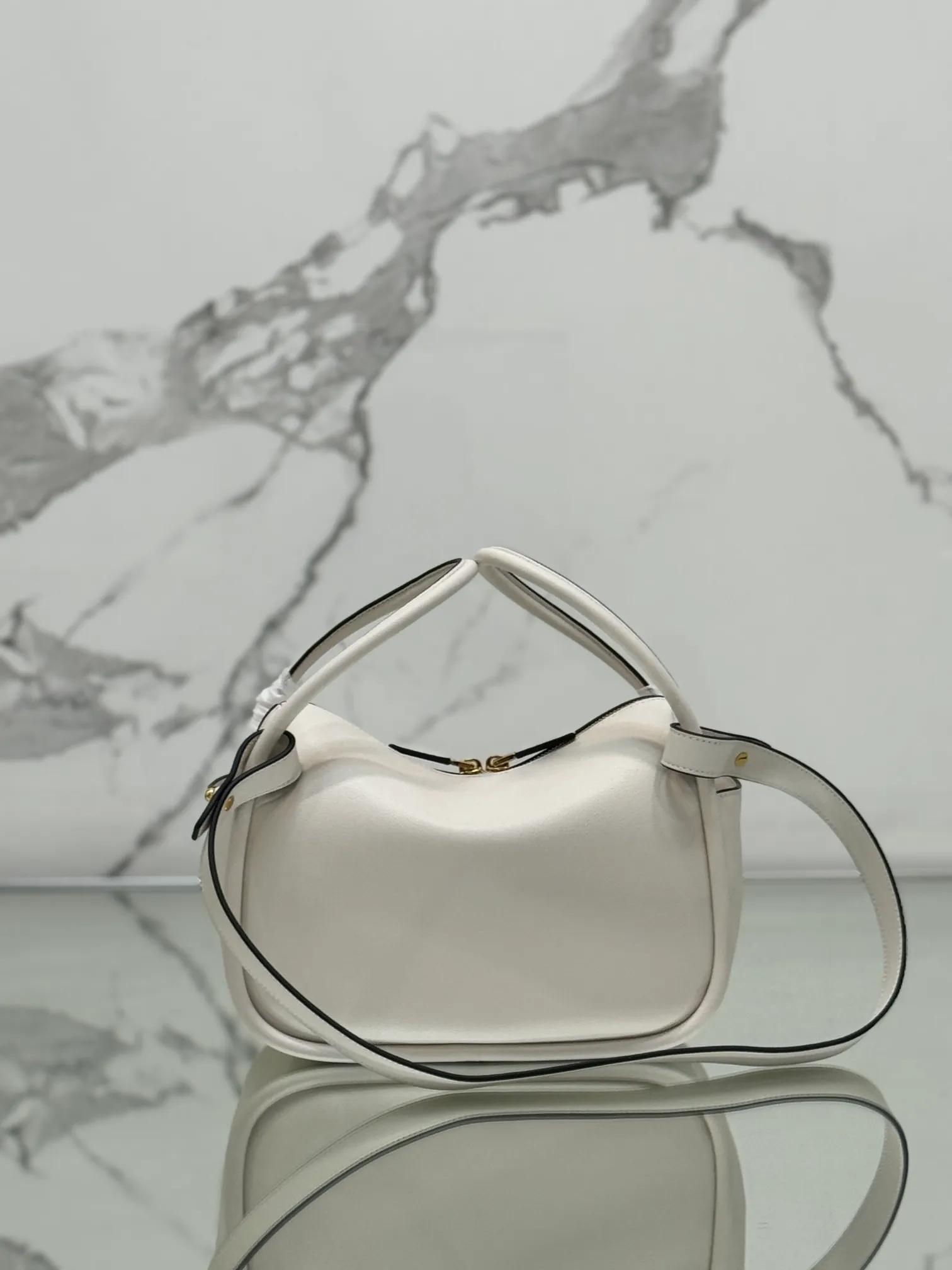 💰1500⭐ New bowling bag This Lindy handbag/shoulder bag is made of Italian Soft Grain imported calfskin, with top-grade hardware. The modern design highlights the casual attitude, and the exquisite details and metal hardware accessories add to the smartness. Sophisticated and versatile, the style is crafted from soft grained cowhide with smooth, minimal lines. Showcasing exceptional craftsmanship, this accessory is embellished with an enameled triangular metal logo. It can be carried by hand, shoulder, or cross-body. It has large capacity, is simple and practical, and has a great upper body😘 ●Double handles, 13 cm drop length ●Detachable shoulder strap, 75 cm long ·Open side pockets·Metal hardware accessories ·Enameled triangular metal logo on the front ·Zipper closure ·Lined and patch pockets Style number: 1ba451 Size: 25*18*10.5cm