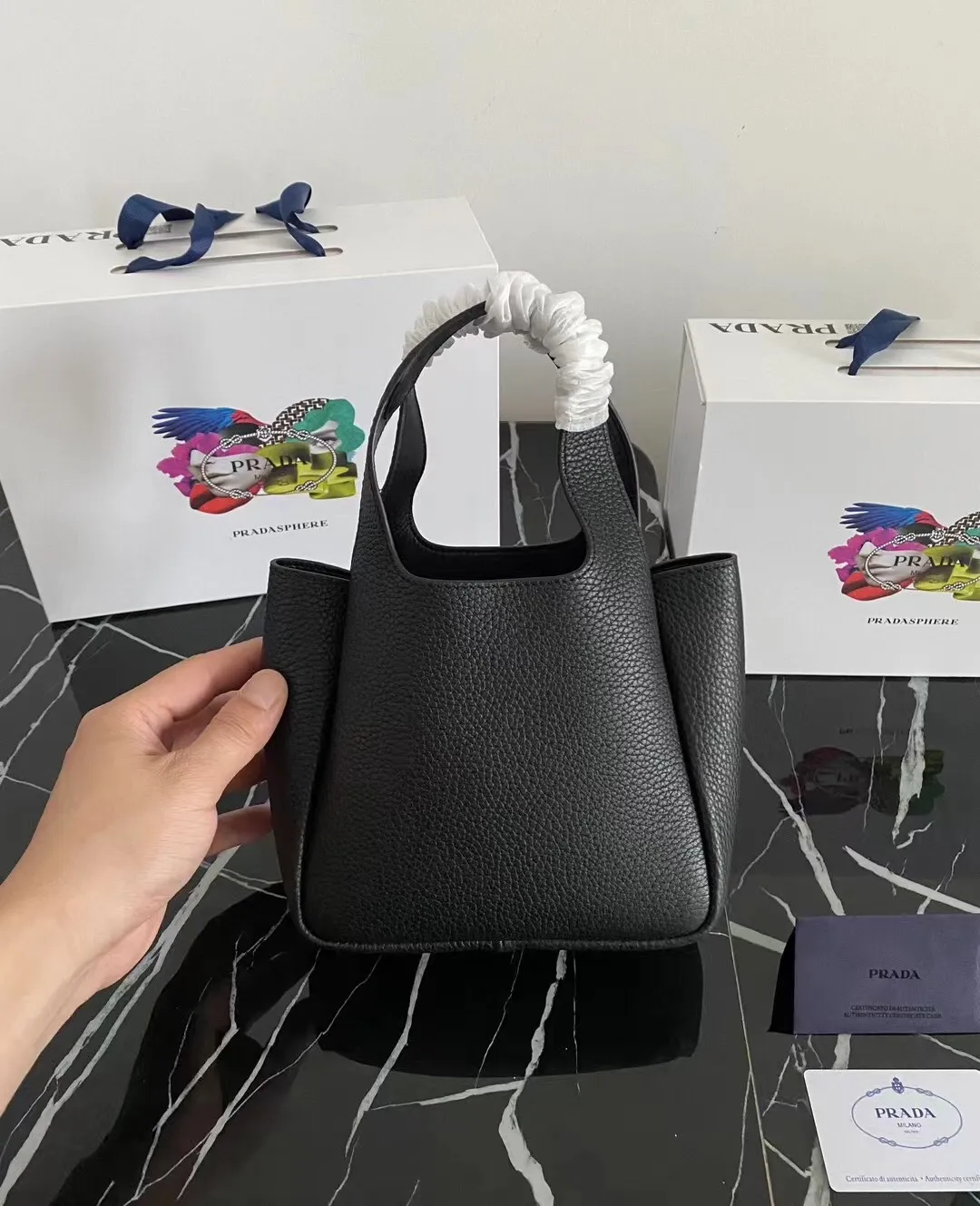 P1100¥ [Top original order] The latest 2022 vegetable basket tote bag mini model 1BA349 has arrived🎉🎉Soft and delicate pebbled calfskin tote bag, full leather inside and outside, equipped with double handles, decorated with silver metal logo, the overall body of the bag is very soft Lightweight, elegant and outstanding. The two side pockets not only meet the needs of exquisite storage but also add an elegant charm. It can be carried as a handbag or an armpit bag. It is a must-have handbag for fairies that perfectly combines classic heritage with the trend of the times. Size: 18︸15.5︸10CM!