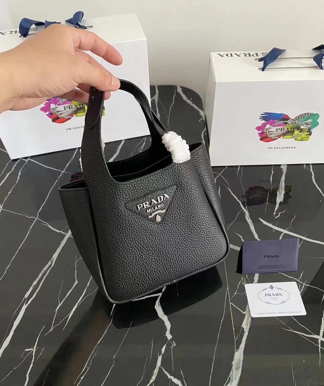 P1100¥ [Top original order] The latest 2022 vegetable basket tote bag mini model 1BA349 has arrived🎉🎉Soft and delicate pebbled calfskin tote bag, full leather inside and outside, equipped with double handles, decorated with silver metal logo, the overall body of the bag is very soft Lightweight, elegant and outstanding. The two side pockets not only meet the needs of exquisite storage but also add an elegant charm. It can be carried as a handbag or an armpit bag. It is a must-have handbag for fairies that perfectly combines classic heritage with the trend of the times. Size: 18︸15.5︸10CM!