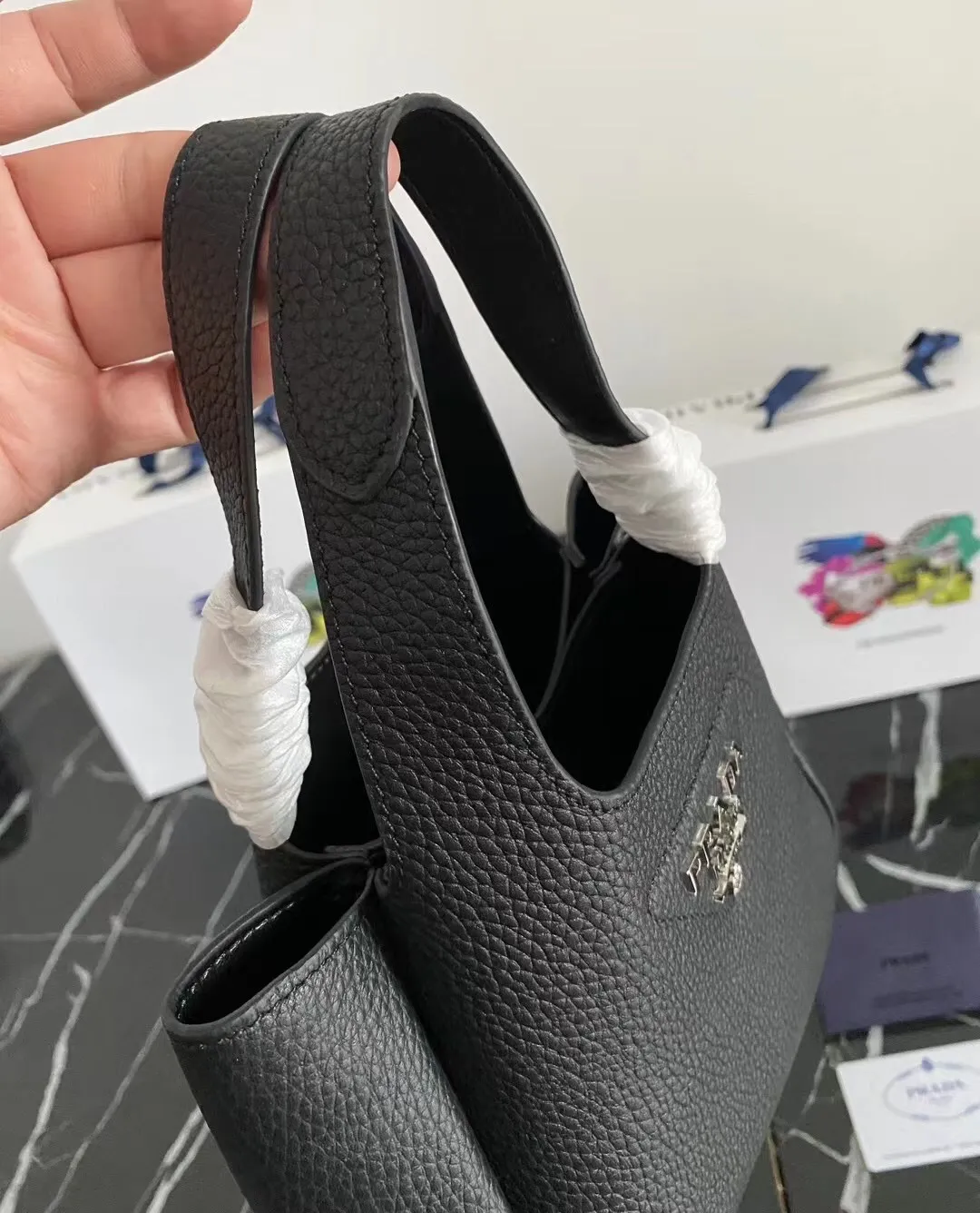 P1100¥ [Top original order] The latest 2022 vegetable basket tote bag mini model 1BA349 has arrived🎉🎉Soft and delicate pebbled calfskin tote bag, full leather inside and outside, equipped with double handles, decorated with silver metal logo, the overall body of the bag is very soft Lightweight, elegant and outstanding. The two side pockets not only meet the needs of exquisite storage but also add an elegant charm. It can be carried as a handbag or an armpit bag. It is a must-have handbag for fairies that perfectly combines classic heritage with the trend of the times. Size: 18︸15.5︸10CM!