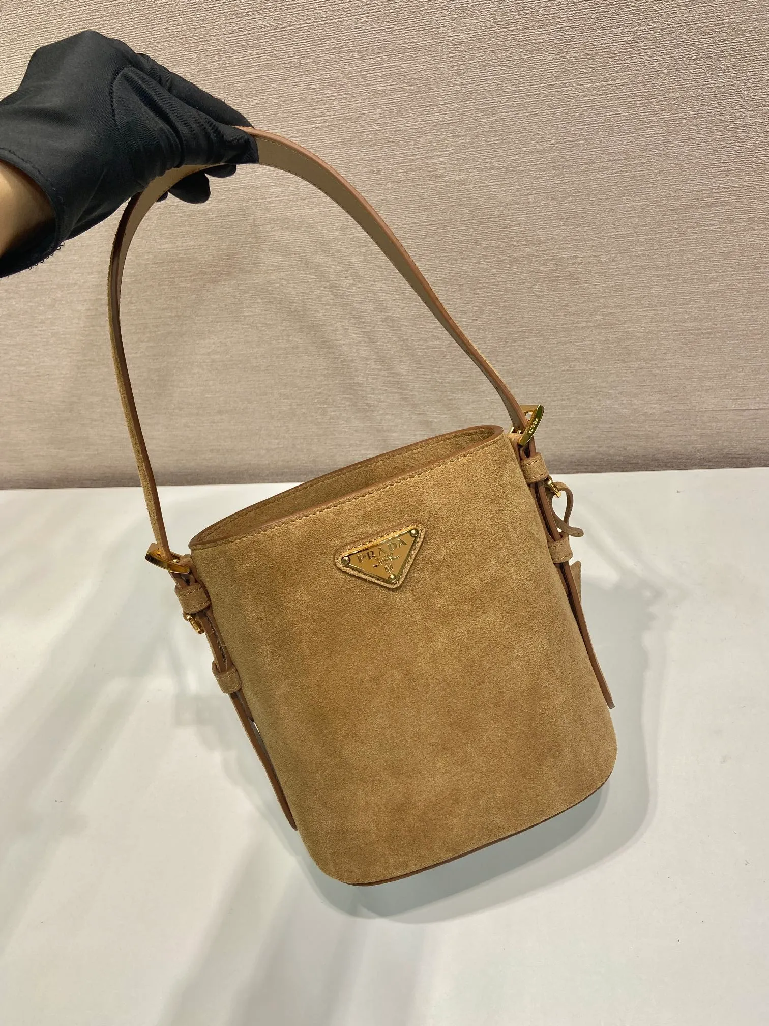 💰1360🎉New Bucket Bag🎉1BE078A Suede Small Size🎉🎉 This flexible and easy-to-wear bucket bag has a minimalist design and is made of soft suede leather. The shoulder straps are adjustable and equipped with imported sheepskin inside. It has a large space and the upper body effect is fashionable. It is a must-have in winter and is worth owning👏👏👏 Length 17 height 18.5 bottom 10.5cm🎉🎉🎉👏👏👏