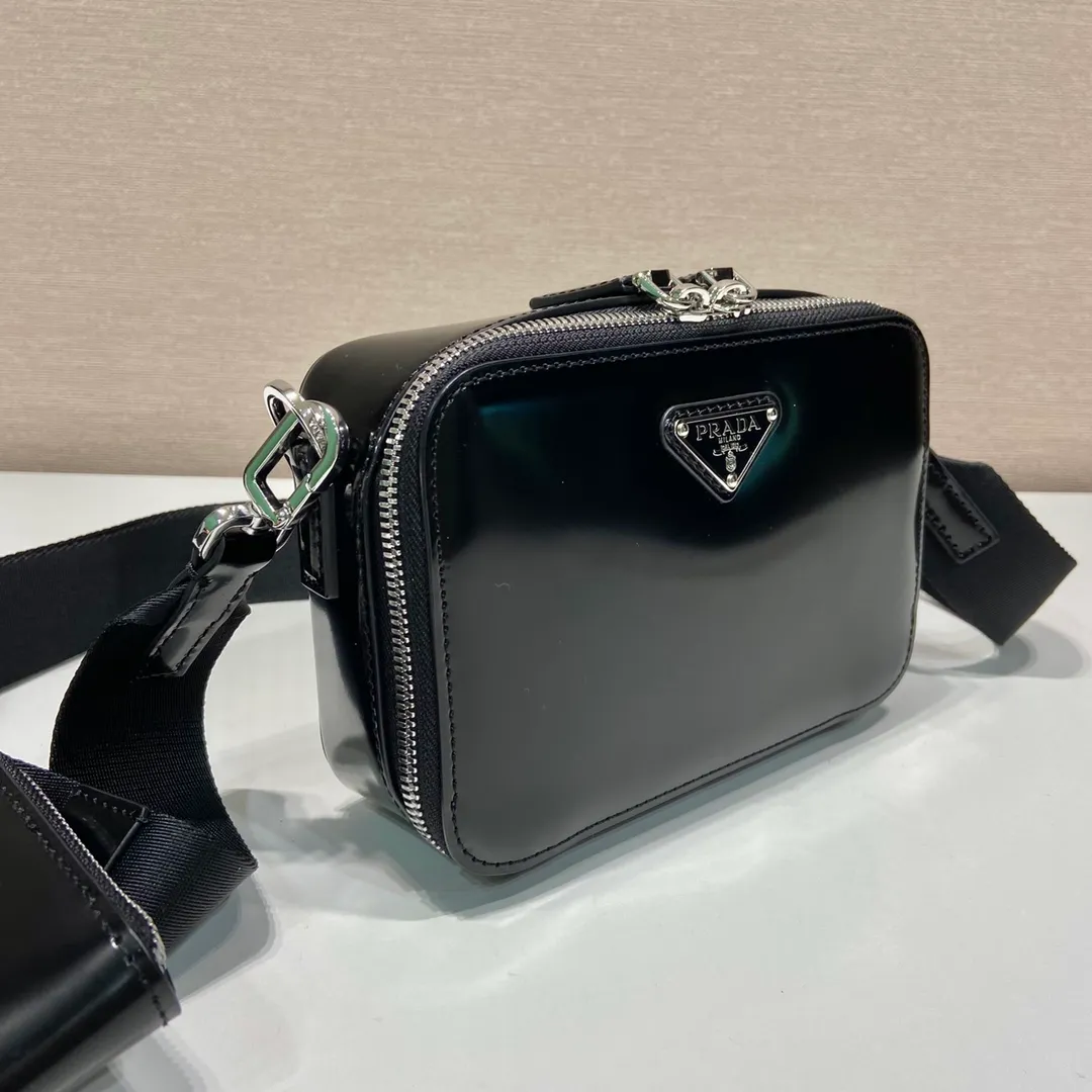 💰1260🎉New messenger bag🎉2VH070 patent leather. This contemporary Brique bag has simple lines, a removable and adjustable nylon shoulder strap and a removable pouch for a lightweight and versatile style. The vintage glossy leather chosen has become the brand’s signature material. It looks classic with original temperament and modern fashion🎉🎉Large capacity and space, worth it, get it now🎉🎉 Length 19x Height 12.5x Bottom 5.5cm