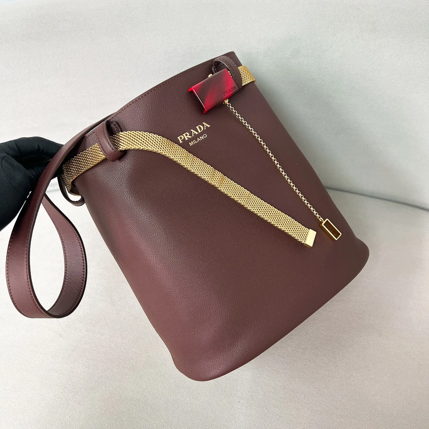 💰1700✨New product launch✨2025 spring and summer new product Buckle bucket bag 1BE085 inherits the classic bucket bag shape. The newly designed leather belt has a unique style that makes the bag infinitely dynamic. It is made of chic and noble calfskin. The bag is decorated with metallic mesh design. It is equipped with tortoise shell panel buckle. Elegant and simple bag body design is decorated with unique hardware decoration, showing a refined and elegant aesthetic style. Equipped with an adjustable hand strap, perfect details comparable to brick cabinets, super awesome 5🌟 size: 29*26.5*18cm, heather wood color