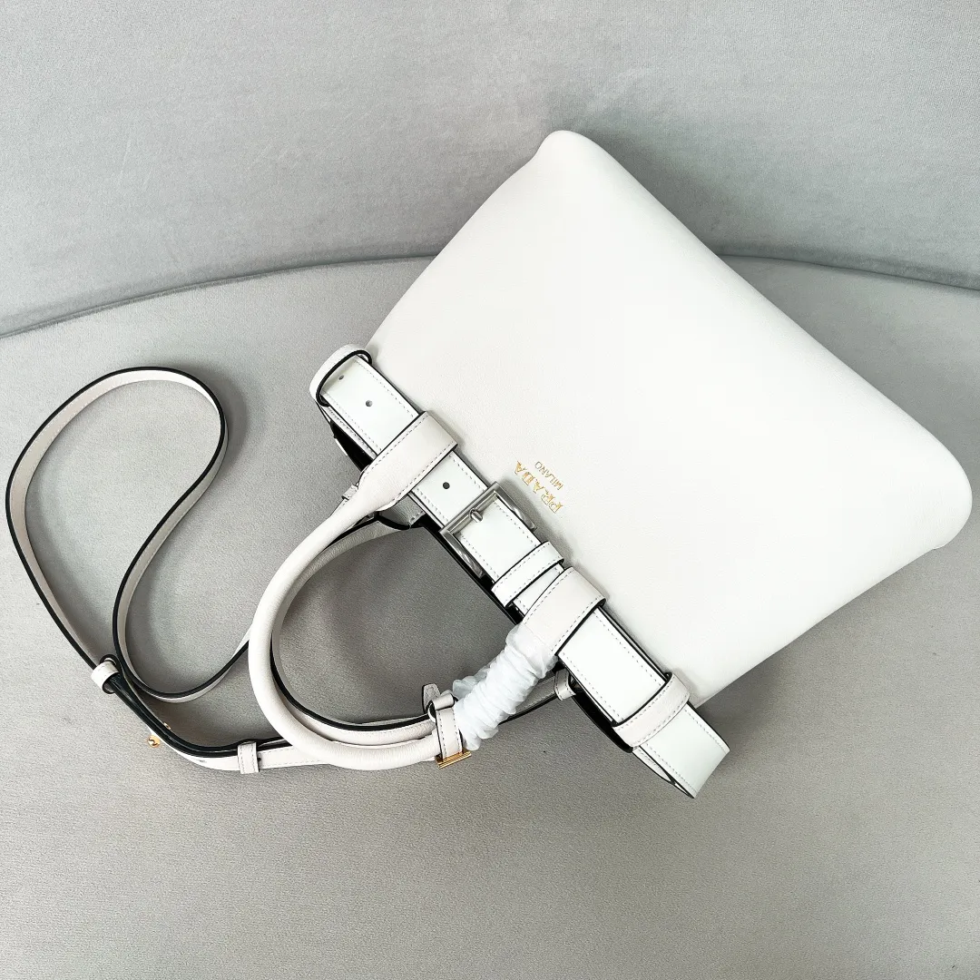 💰2040✨New product launch✨2024 early spring new medium wide drawstring leather handbag 1Ba434 Newly designed leather belt with unique style makes the bag infinitely dynamic. Made of chic and noble lambskin. Elegant and simple body design. Classic gold logo logo on the front. Equipped with adjustable shoulder straps, can be carried or worn cross-body. It has three compartments to meet exquisite storage needs. The perfect details are comparable to those of a brick cabinet. Super 5🌟 size: 32*23*11cm white