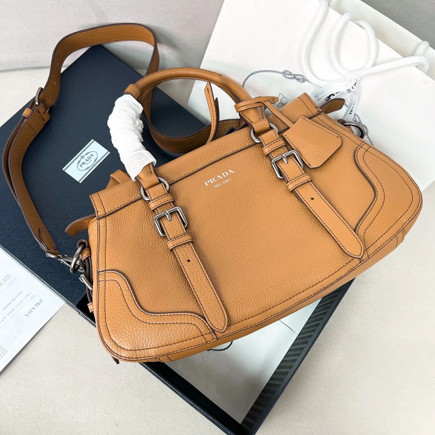 💰1900🌟New product launch🌟2025 autumn and winter new pebbled tote bag 1BG604 is carefully made of imported deerskin. Delicate irregular texture creates a luxurious texture. Reinforced corner design shows the spirit of craftsmanship. Full leather handle➕Detachable and adjustable shoulder strap. Embossed letter logo on the front. It is not only practical, lightweight but also good-looking. The spacious internal double compartment is simply awesome👏 The new favorite of fashionistas. The perfect details are comparable to brick cabinets. Super awesome 5🌟 Size: 35*22*11cm caramel color