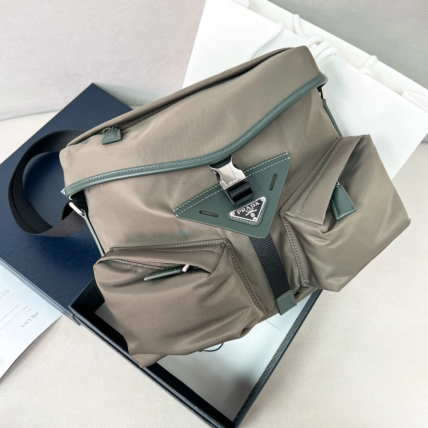 💰1320✨New product launch✨Early spring new nylon messenger bag 2VD062 The new series of main messenger bags interprets its duality core. Nylon➕calfskin. The geometric bag is avant-garde and trendy with exquisite aesthetics and practical functions. Imported parachute nylon fabric is waterproof and wear-resistant. Super textured calfskin trim. Classic triangular enamel front logo. The overall bag body is casual and not afraid of deformation. Multi-pocket design meets various storage needs for daily travel. Fashionable, casual and versatile. Jimei friends, come and plant grass. Size: 29*23*15 Forest Green