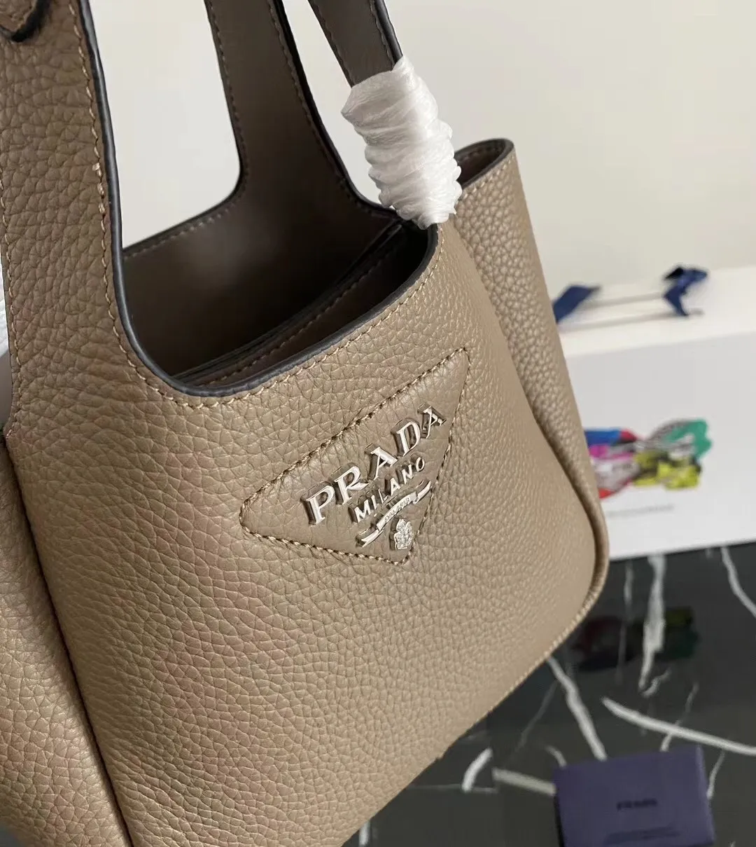 P1100¥ [Top original order] The latest 2022 vegetable basket tote bag mini model 1BA349 has arrived🎉🎉Soft and delicate pebbled calfskin tote bag, full leather inside and outside, equipped with double handles, decorated with silver metal logo, the overall body of the bag is very soft Lightweight, elegant and outstanding. The two side pockets not only meet the needs of exquisite storage but also add an elegant charm. It can be carried as a handbag or an armpit bag. It is a must-have handbag for fairies that perfectly combines classic heritage with the trend of the times. Size: 18︸15.5︸10CM!