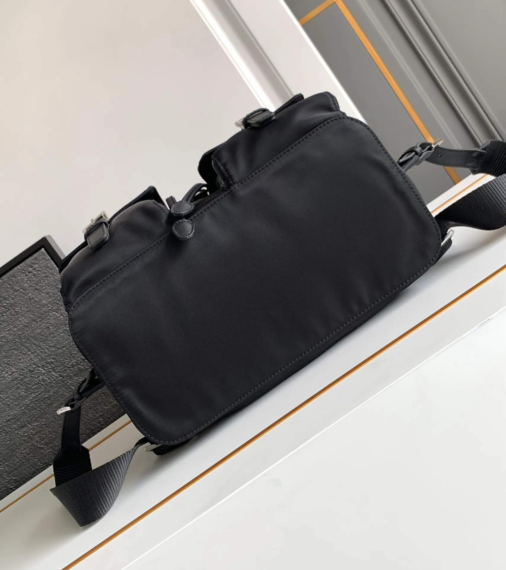 P640¥PR@DA 1BZ811 Nylon backpack is the most classic, best-selling and most versatile backpack of the P family. It is the first nylon bag designed by the chief founder himself. It is lightweight, rainproof, has a moderate capacity and is suitable for travel. It is matched with imported parachute fabric - waterproof and sunproof. Triangular enamel logo on the front, cross pattern cowhide trim. The overall style is fashionable and casual, yet stable and dignified. It has a large capacity to hold a kettle, iPad, mobile phone, books and documents. The drawstring inner bag + the two front zipper outer pockets meet the exquisite storage needs [Celebration]: 32*30*15cm black