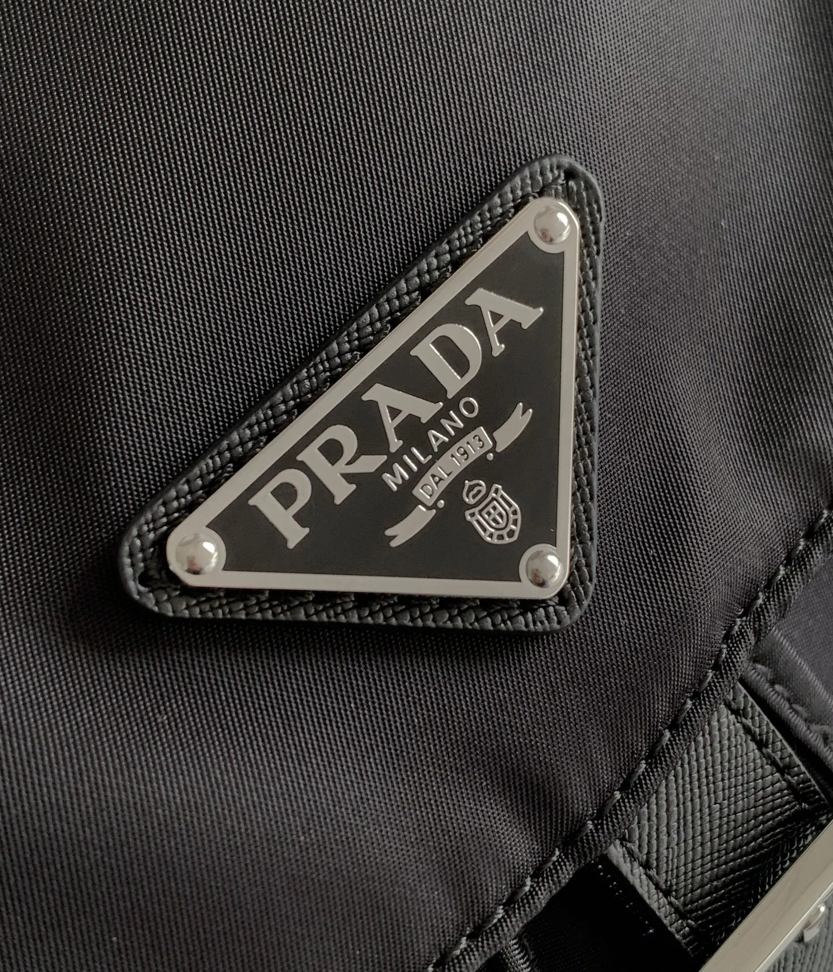 P640¥PR@DA 1BZ811 Nylon backpack is the most classic, best-selling and most versatile backpack of the P family. It is the first nylon bag designed by the chief founder himself. It is lightweight, rainproof, has a moderate capacity and is suitable for travel. It is matched with imported parachute fabric - waterproof and sunproof. Triangular enamel logo on the front, cross pattern cowhide trim. The overall style is fashionable and casual, yet stable and dignified. It has a large capacity to hold a kettle, iPad, mobile phone, books and documents. The drawstring inner bag + the two front zipper outer pockets meet the exquisite storage needs [Celebration]: 32*30*15cm black
