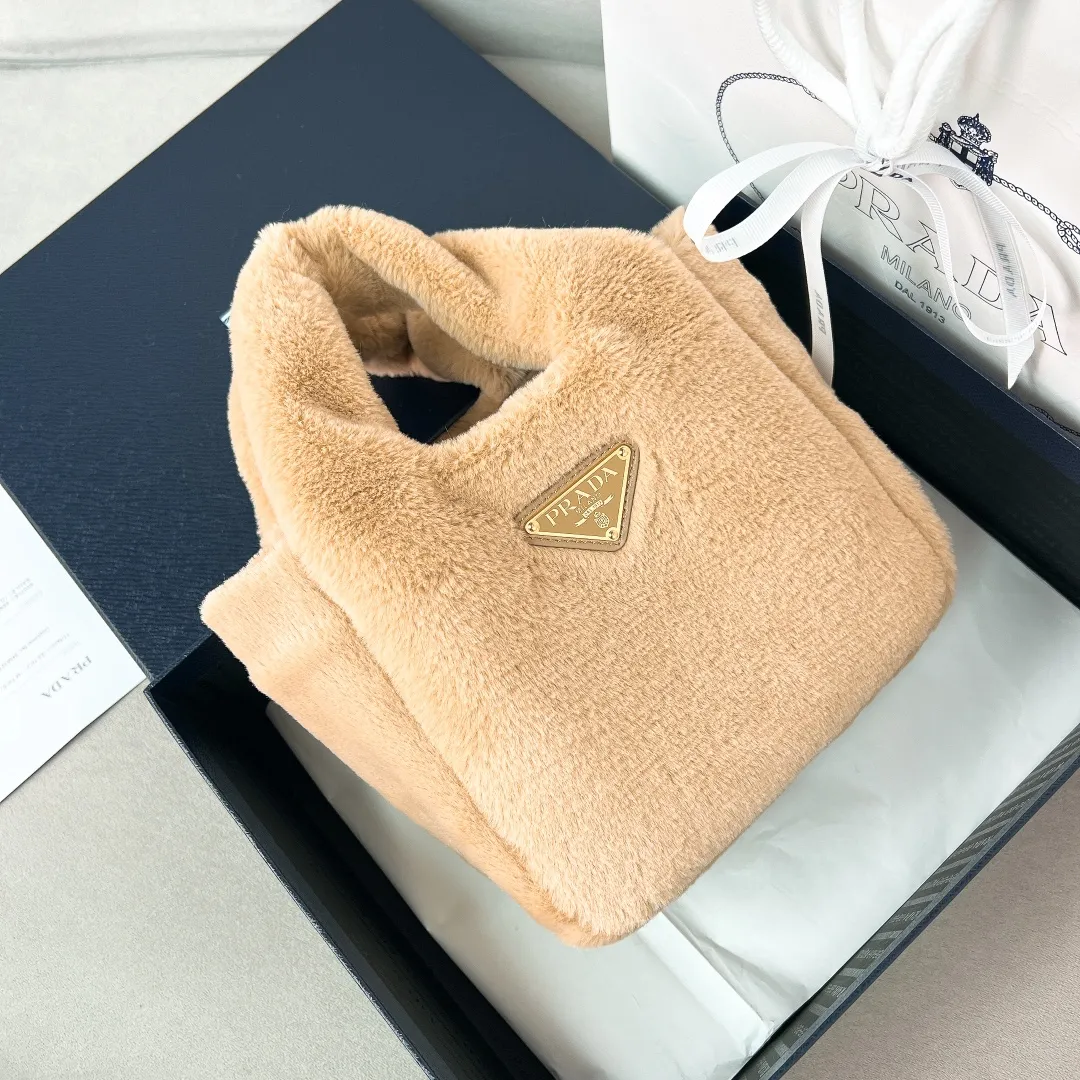 💰1300✨New product launch✨2023 autumn and winter new plush vegetable basket 1BA349. Made of soft and fine plush material with calfskin. Equipped with double handles decorated with golden metal logo. The overall bag body is very soft and lightweight. The style is elegant and outstanding. The two side pockets not only meet the needs of exquisite storage but also add elegant charm. A handbag that perfectly combines classic heritage and the trend of the times. A must-have for fairies. Size 15.5*18*10cm