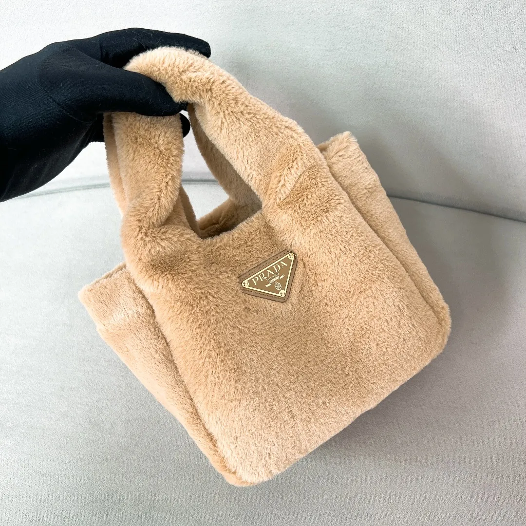 💰1300✨New product launch✨2023 autumn and winter new plush vegetable basket 1BA349. Made of soft and fine plush material with calfskin. Equipped with double handles decorated with golden metal logo. The overall bag body is very soft and lightweight. The style is elegant and outstanding. The two side pockets not only meet the needs of exquisite storage but also add elegant charm. A handbag that perfectly combines classic heritage and the trend of the times. A must-have for fairies. Size 15.5*18*10cm
