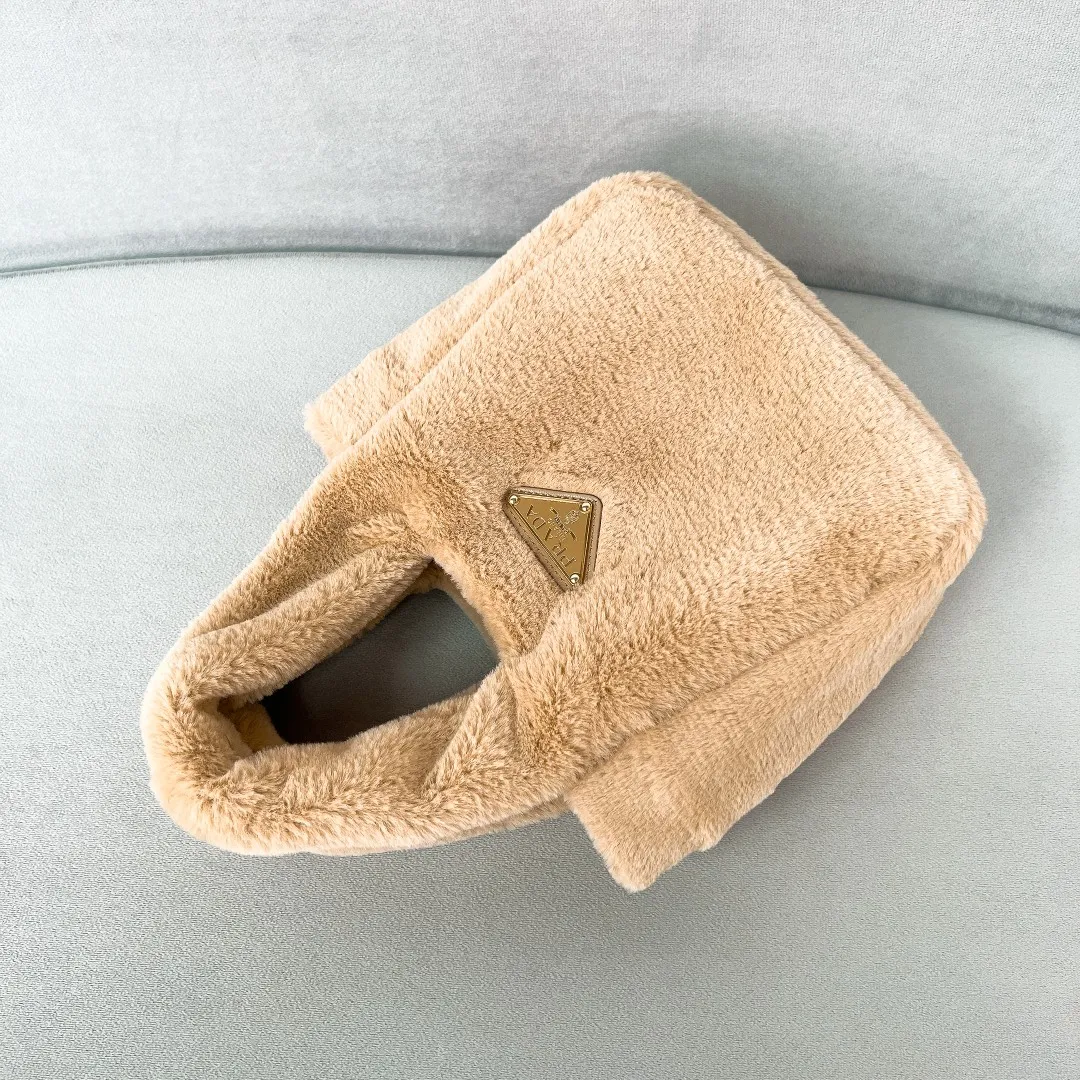 💰1300✨New product launch✨2023 autumn and winter new plush vegetable basket 1BA349. Made of soft and fine plush material with calfskin. Equipped with double handles decorated with golden metal logo. The overall bag body is very soft and lightweight. The style is elegant and outstanding. The two side pockets not only meet the needs of exquisite storage but also add elegant charm. A handbag that perfectly combines classic heritage and the trend of the times. A must-have for fairies. Size 15.5*18*10cm