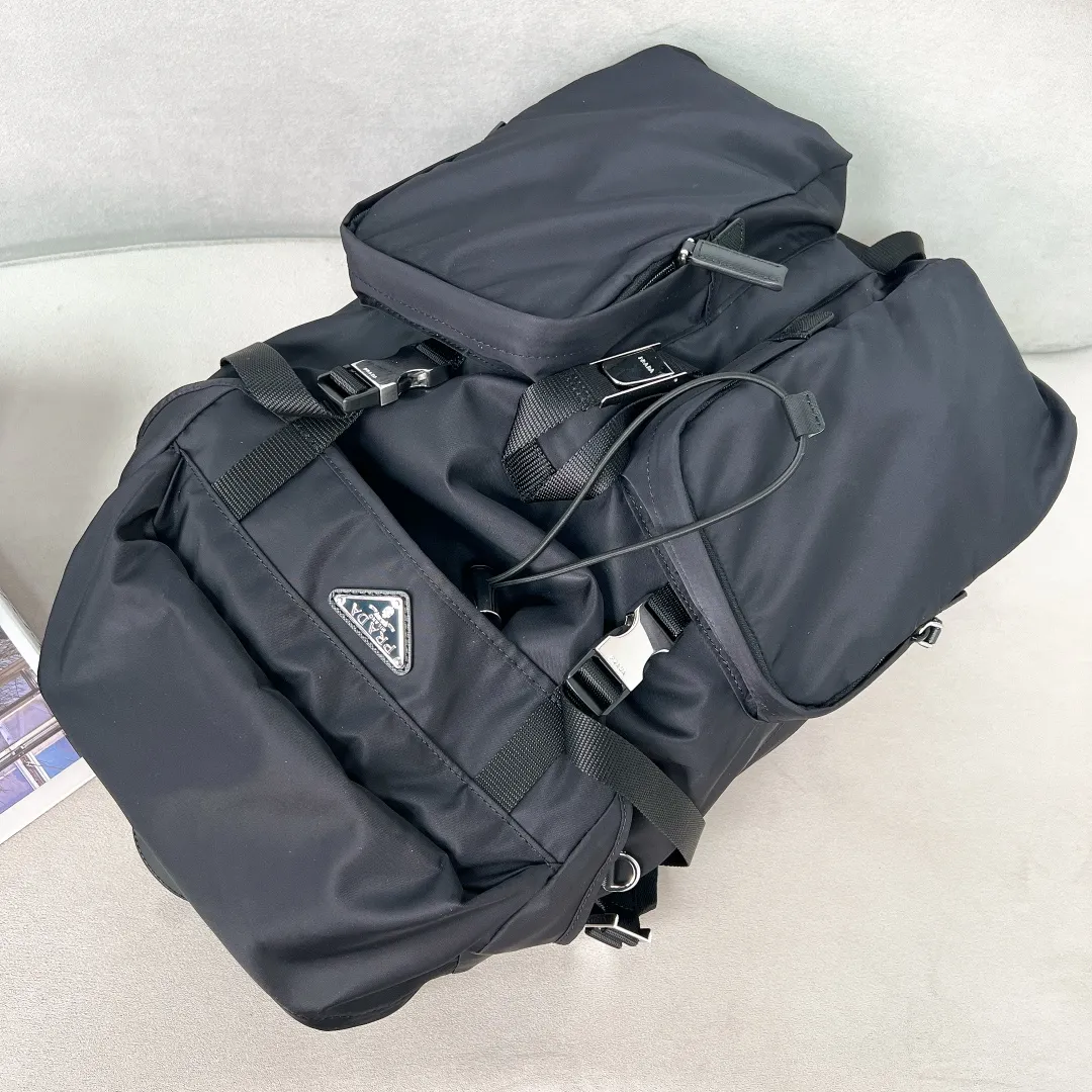 💰1860✨New product launch✨2023 autumn and winter new men's travel backpack 2VZ019 The classic parachute material backpack is new. Made of imported nylon fabric. The latest design is quite technological. The main compartment of the backpack is equipped with a flap and buckle. Internal zipper pockets and patch pockets. Two external zipper pockets and two drawstring water bottle pockets. The padded mesh back is breathable and more comfortable. Leather handles➕Adjustable woven nylon straps, spacious, highly functional, and super cool on the upper body! The perfect details are comparable to brick cabinets🌟Awesome!  Size: 53.5cm high, 16.5cm long, 32cm wide