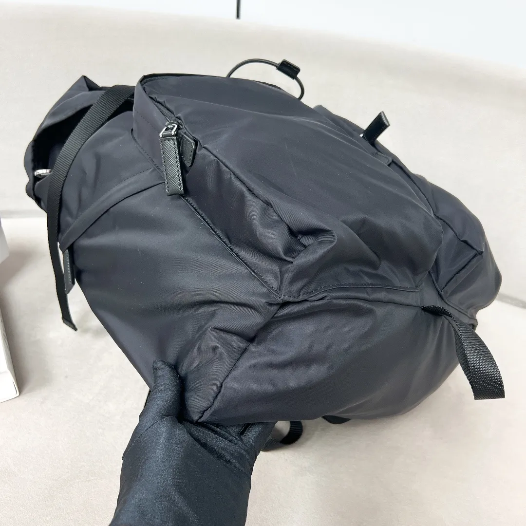 💰1860✨New product launch✨2023 autumn and winter new men's travel backpack 2VZ019 The classic parachute material backpack is new. Made of imported nylon fabric. The latest design is quite technological. The main compartment of the backpack is equipped with a flap and buckle. Internal zipper pockets and patch pockets. Two external zipper pockets and two drawstring water bottle pockets. The padded mesh back is breathable and more comfortable. Leather handles➕Adjustable woven nylon straps, spacious, highly functional, and super cool on the upper body! The perfect details are comparable to brick cabinets🌟Awesome!  Size: 53.5cm high, 16.5cm long, 32cm wide